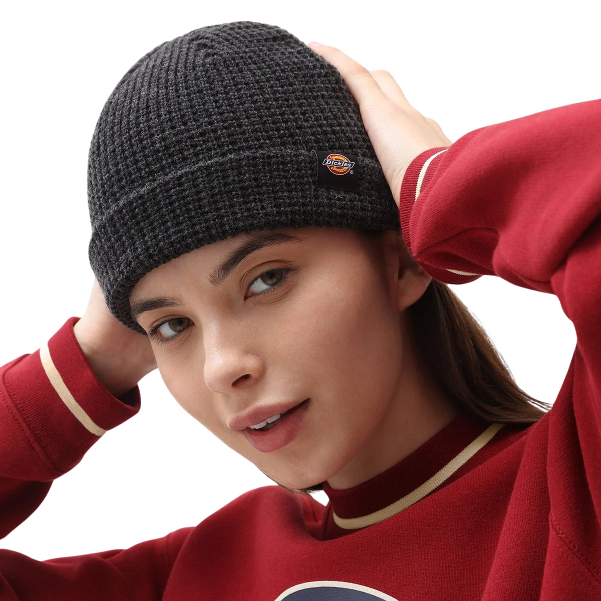 Modelo a ajustar o gorro Dickies Woodworth Waffle preto com as duas mãos, com etiqueta visível na dobra.
