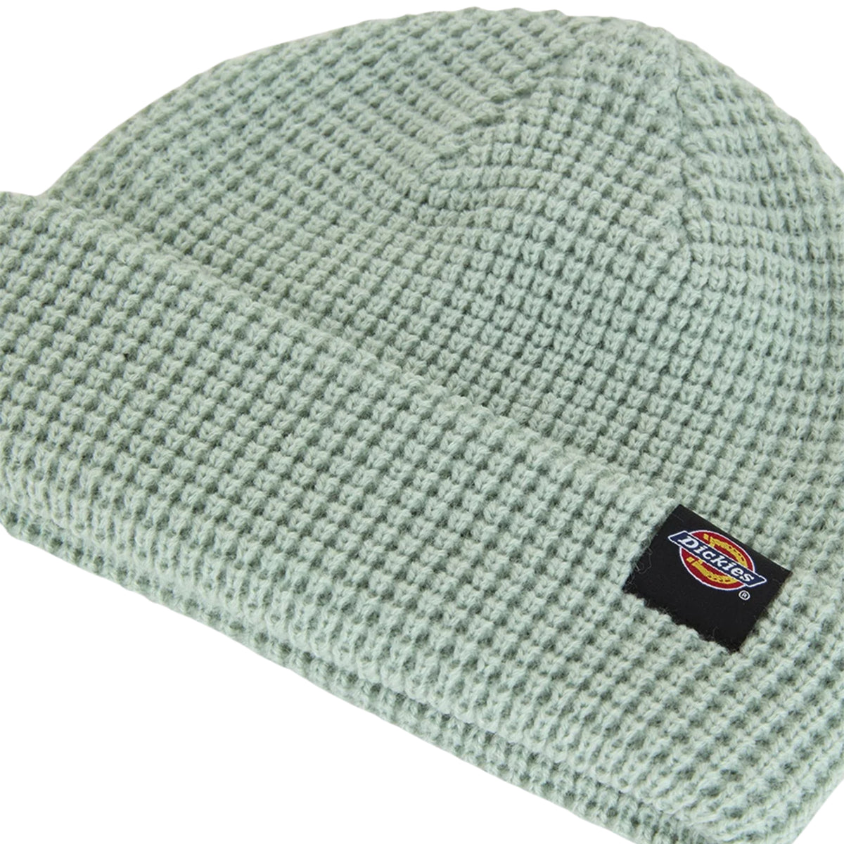Pormenor da textura waffle e da etiqueta Dickies cosida na dobra do gorro verde Jadeite.
