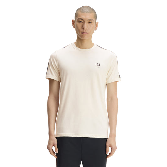 T-shirt de manga curta Fred Perry Contrast Tape Ringer em Ecru — modelo de frente, meio corpo superior, t-shirt ecru de algodão com fita desportiva azul-marinho no ombro e na manga, padrão de coroas de louros e coroa de louros Fred Perry bordada no peito esquerdo, fundo branco.