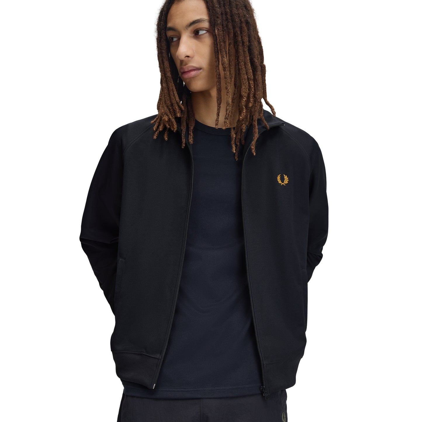 Track jacket Fred Perry Contrast Tape Track Jacket em Navy — vista frontal com modelo, meio corpo, fecho zip aberto, bordado Laurel Wreath em Golden no peito esquerdo, t-shirt navy por baixo visível.