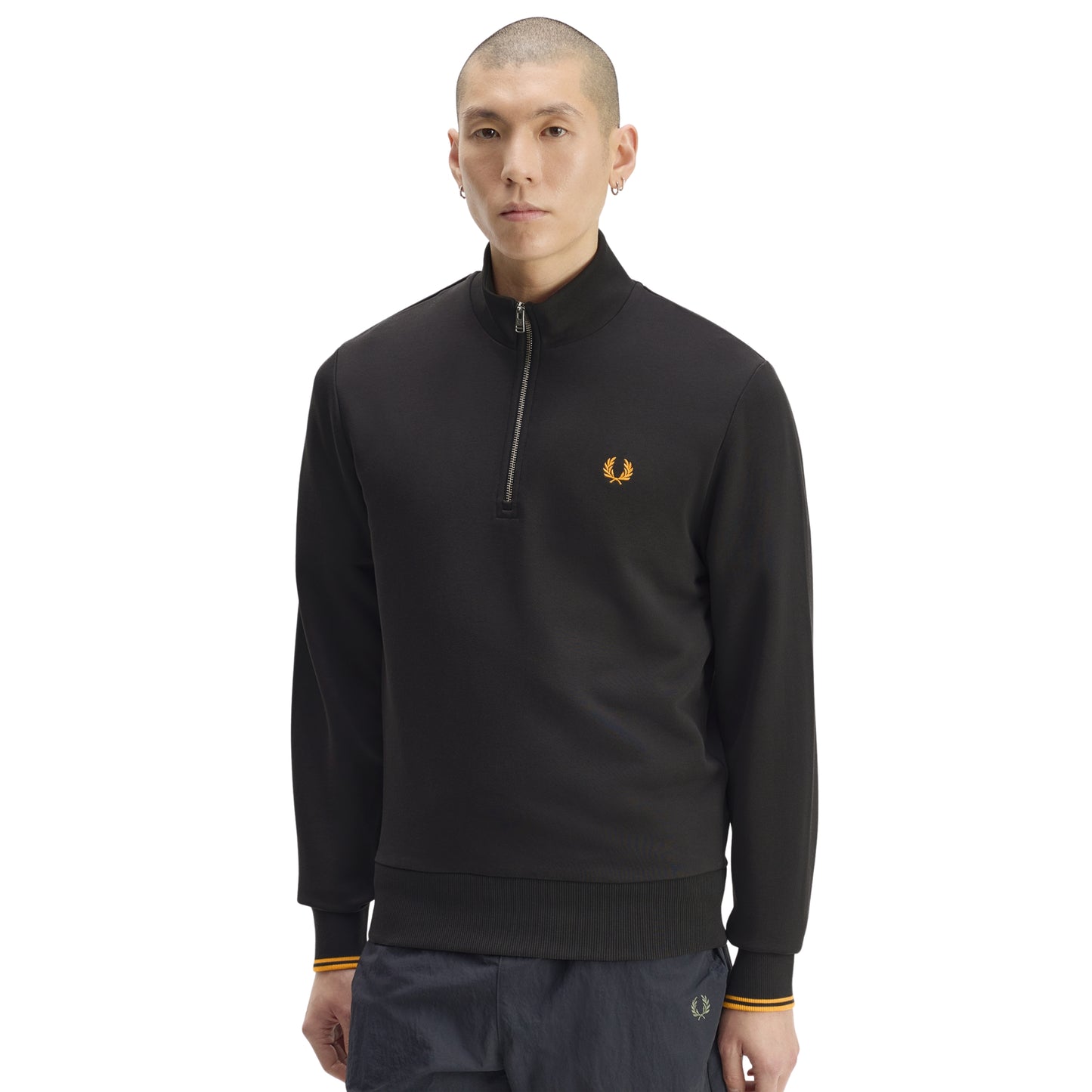 Sweat com meio-fecho Fred Perry Half Zip Sweatshirt em Anchor Grey — vista frontal com modelo, meio corpo, ângulo ligeiramente diferente, bordado Laurel Wreath em Golden e twin tipping Golden nos punhos visíveis, combinado com calças navy.