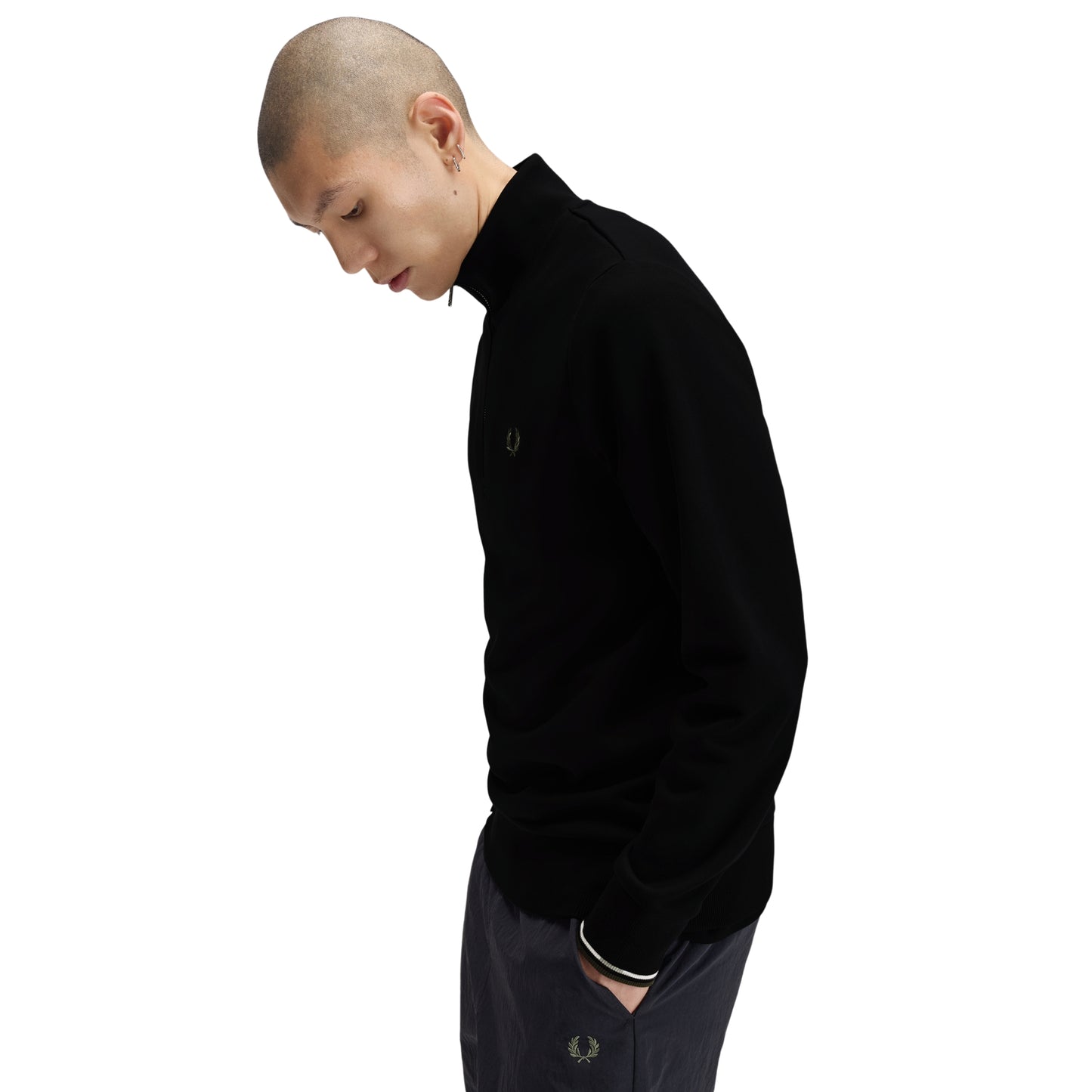 Sweat com meio-fecho Fred Perry Half Zip Sweatshirt em Black — detalhe do punho com twin tipping Ecru/Laurel Wreath Green na proporção 5-4-4, bordado Laurel Wreath em Laurel Wreath Green nas calças navy visível.