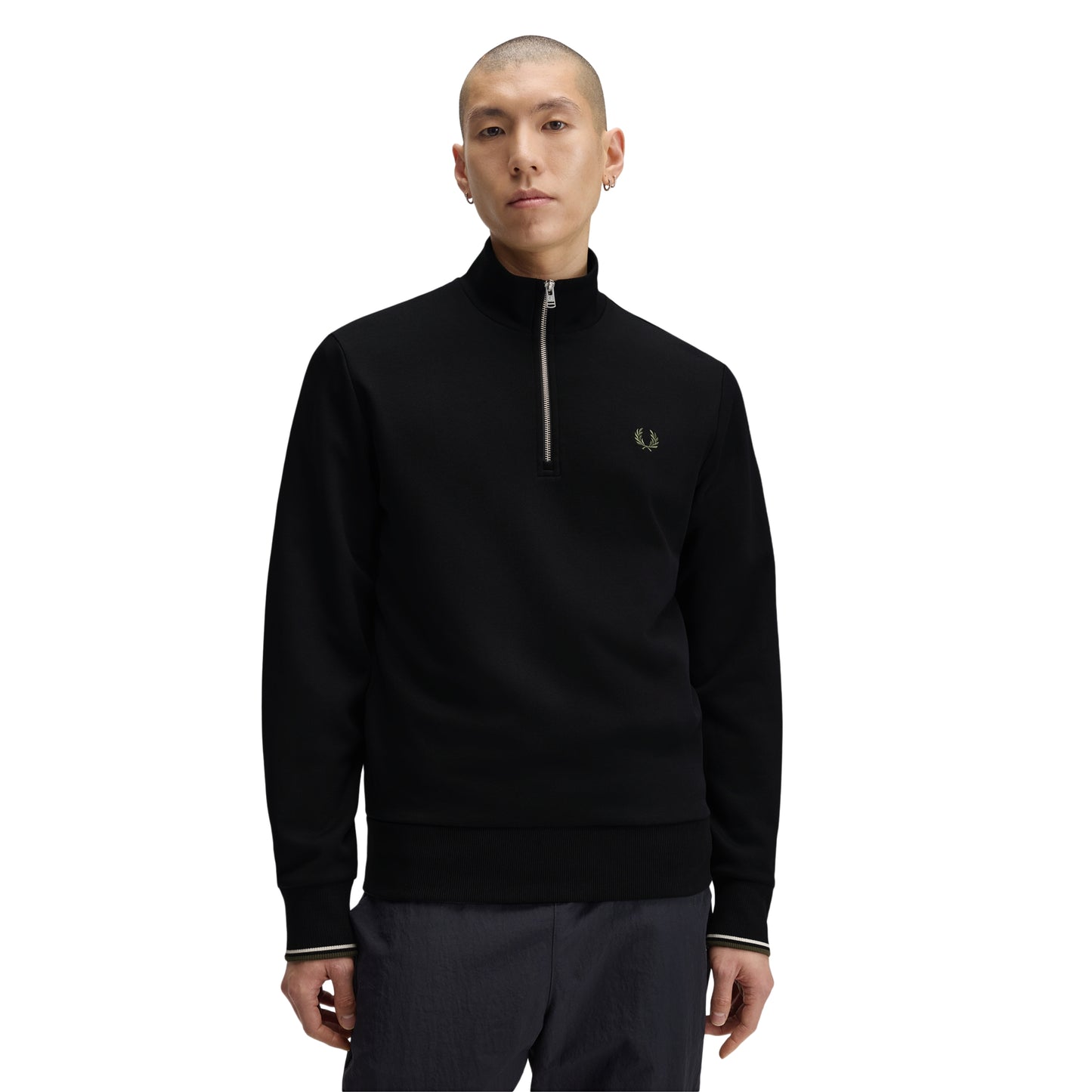 Sweat com meio-fecho Fred Perry Half Zip Sweatshirt em Black — vista frontal com modelo, meio corpo, meio-fecho metálico fechado, bordado Laurel Wreath em Laurel Wreath Green no peito esquerdo, twin tipping Ecru/Laurel Wreath Green nos punhos, combinado com calças navy.