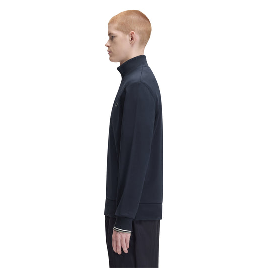 Sweat com meio-fecho Fred Perry Half Zip Sweatshirt em Dark Airforce — vista lateral com modelo, meio corpo, perfil do meio-fecho e gola alta visíveis, combinado com calças pretas Fred Perry.
