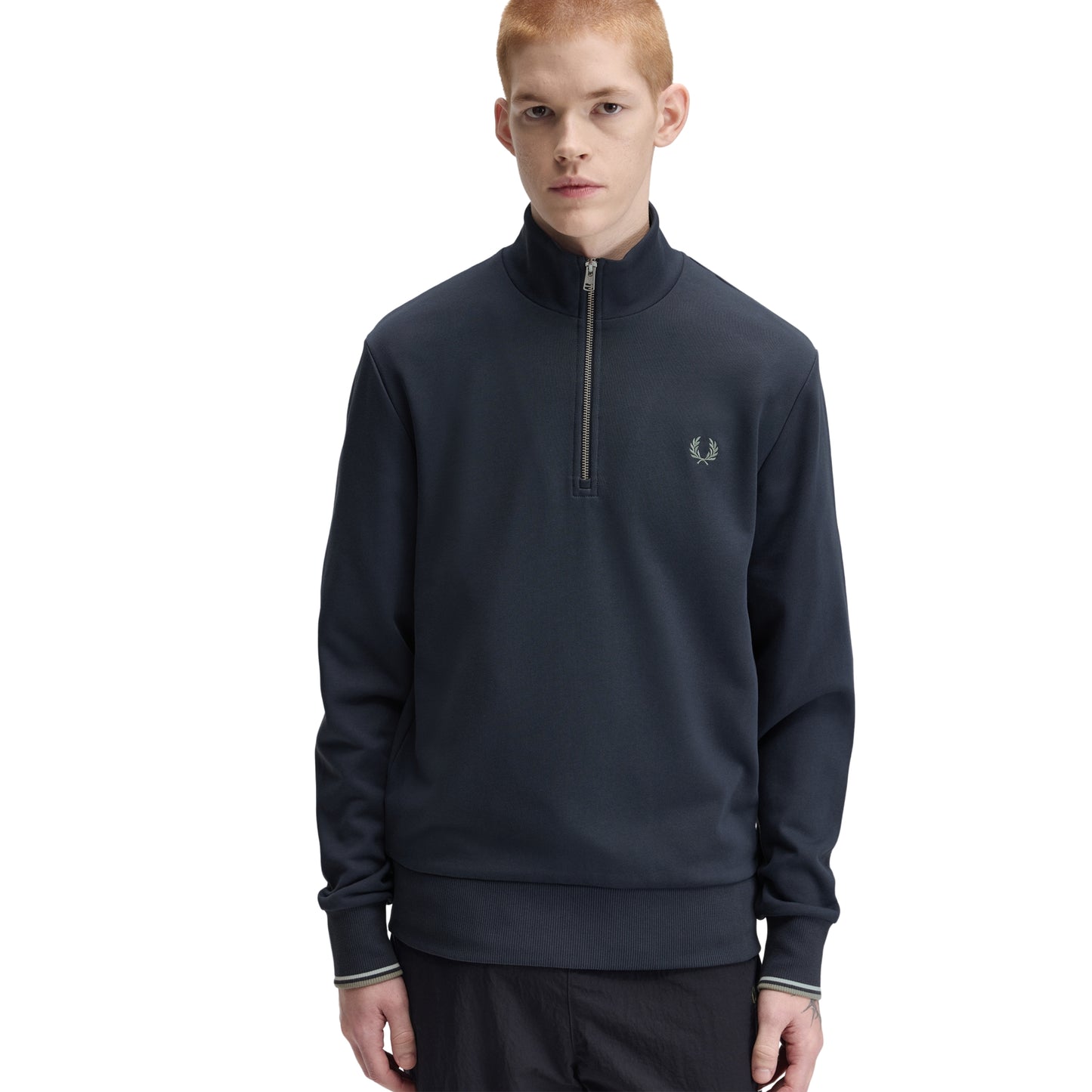 Sweat com meio-fecho Fred Perry Half Zip Sweatshirt em Dark Airforce — vista frontal com modelo, meio corpo, meio-fecho aberto, bordado Laurel Wreath em Seagrass e t-shirt branca por baixo visíveis.