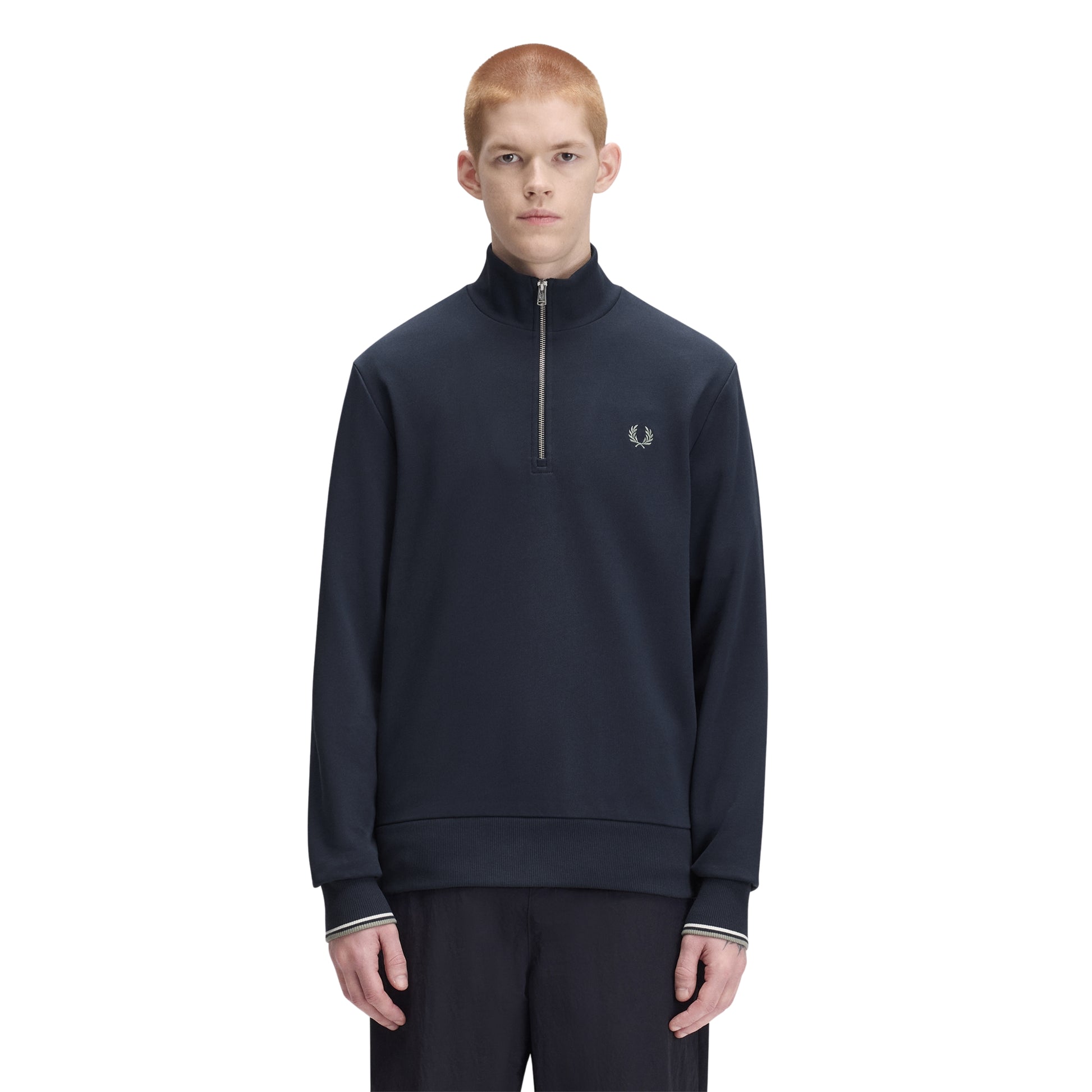 Sweat com meio-fecho Fred Perry Half Zip Sweatshirt em Dark Airforce — vista frontal com modelo, meio corpo, meio-fecho fechado, bordado Laurel Wreath em Seagrass no peito esquerdo, combinado com calças pretas Fred Perry.