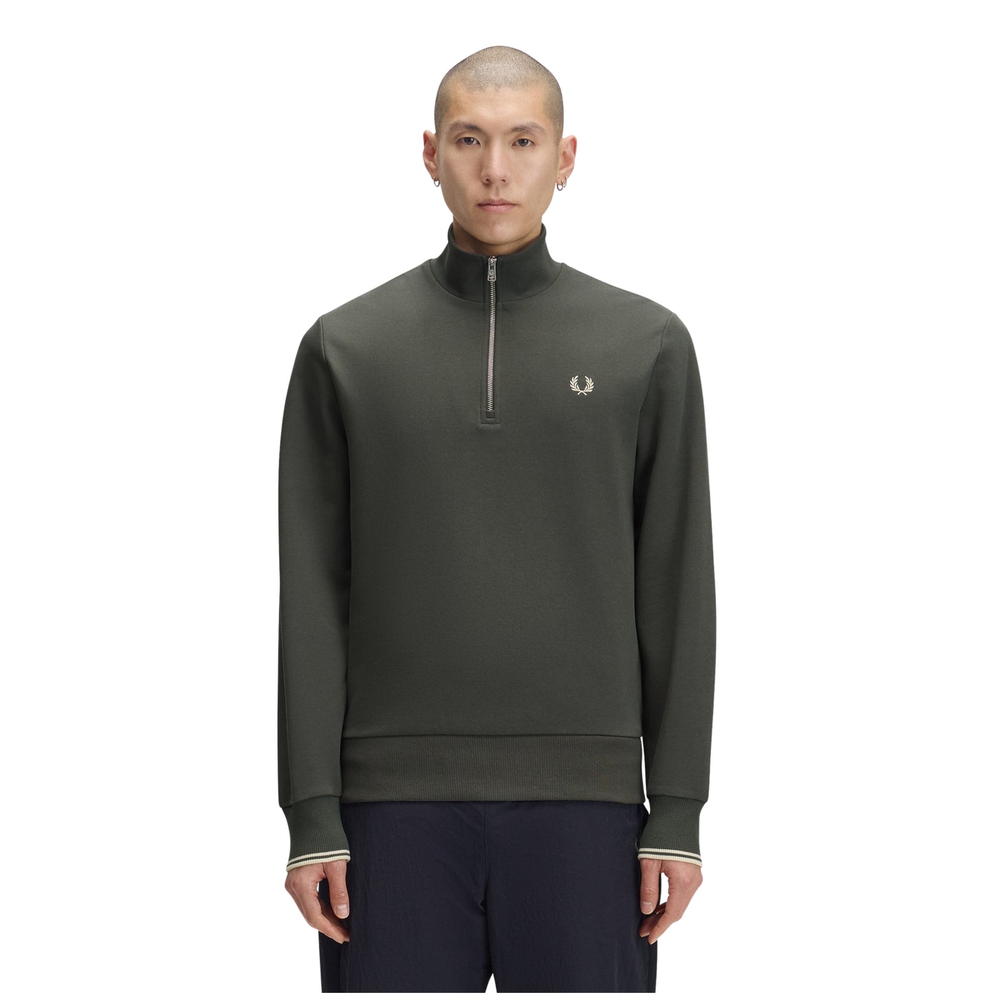 Sweat com meio-fecho Fred Perry Half Zip Sweatshirt em Field Green — vista frontal com modelo, corpo inteiro, meio-fecho fechado, bordado Laurel Wreath em Oatmeal e twin tipping nos punhos visíveis, combinado com calças navy Fred Perry.
