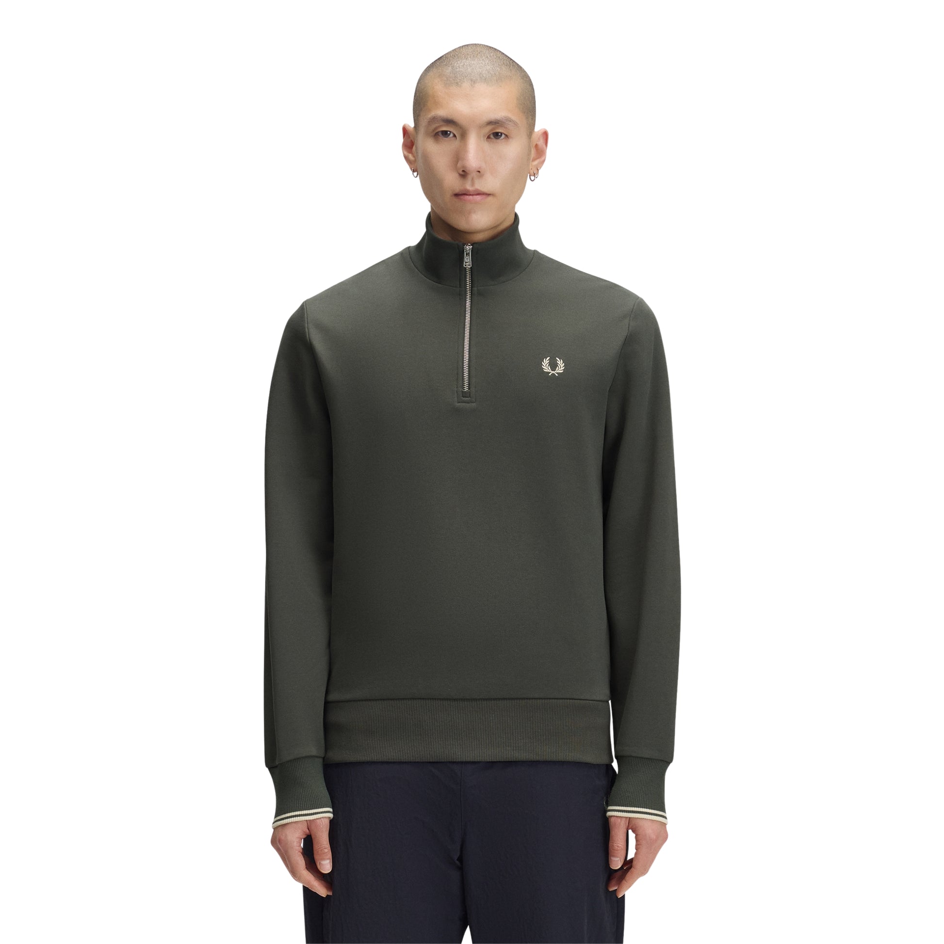 Sweat com meio-fecho Fred Perry Half Zip Sweatshirt em Field Green — vista frontal com modelo, corpo inteiro, meio-fecho fechado, bordado Laurel Wreath em Oatmeal e twin tipping nos punhos visíveis, combinado com calças navy Fred Perry.