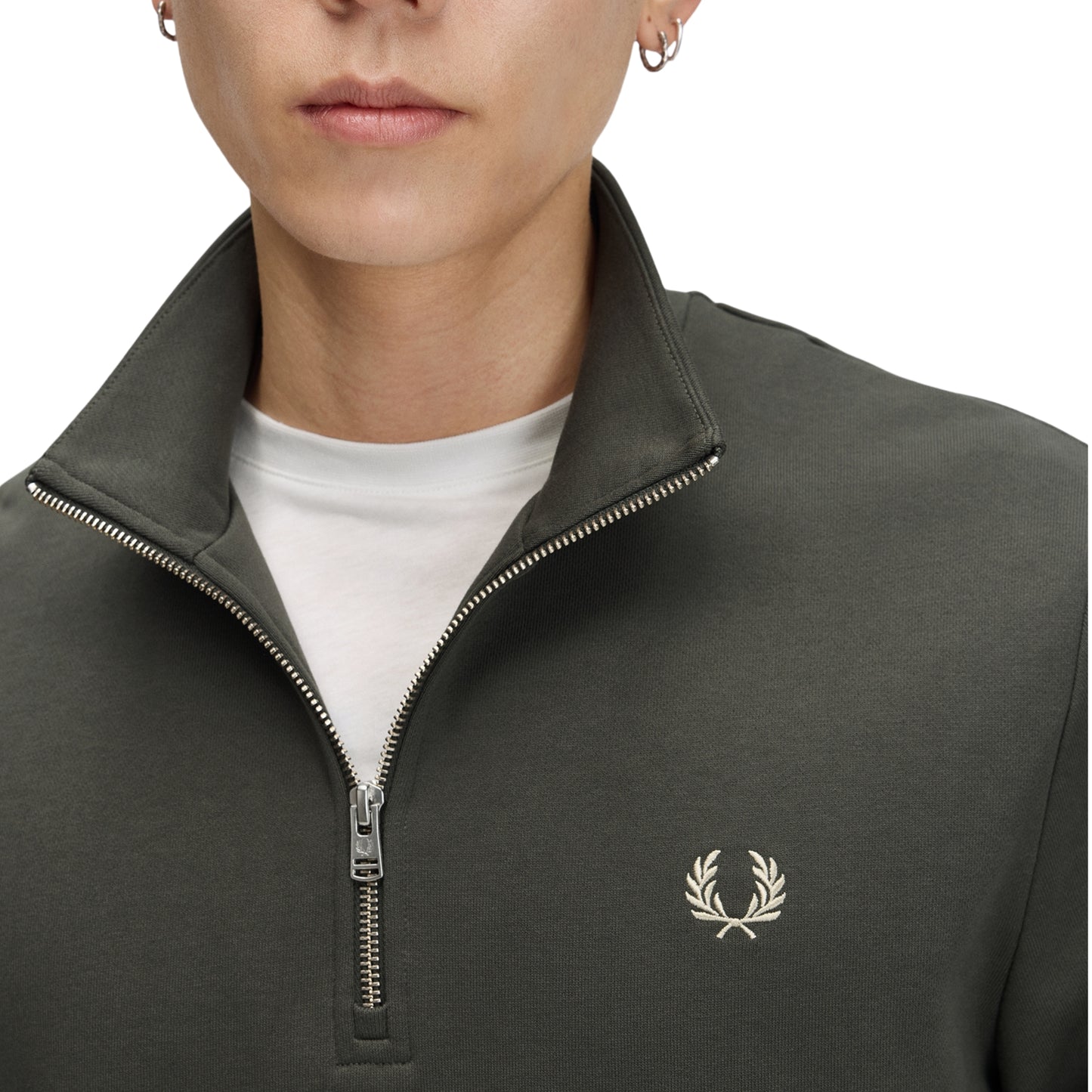 Sweat com meio-fecho Fred Perry Half Zip Sweatshirt em Field Green — detalhe do meio-fecho aberto em calibre fino e bordado Laurel Wreath em Oatmeal no peito esquerdo, t-shirt branca por baixo visível.