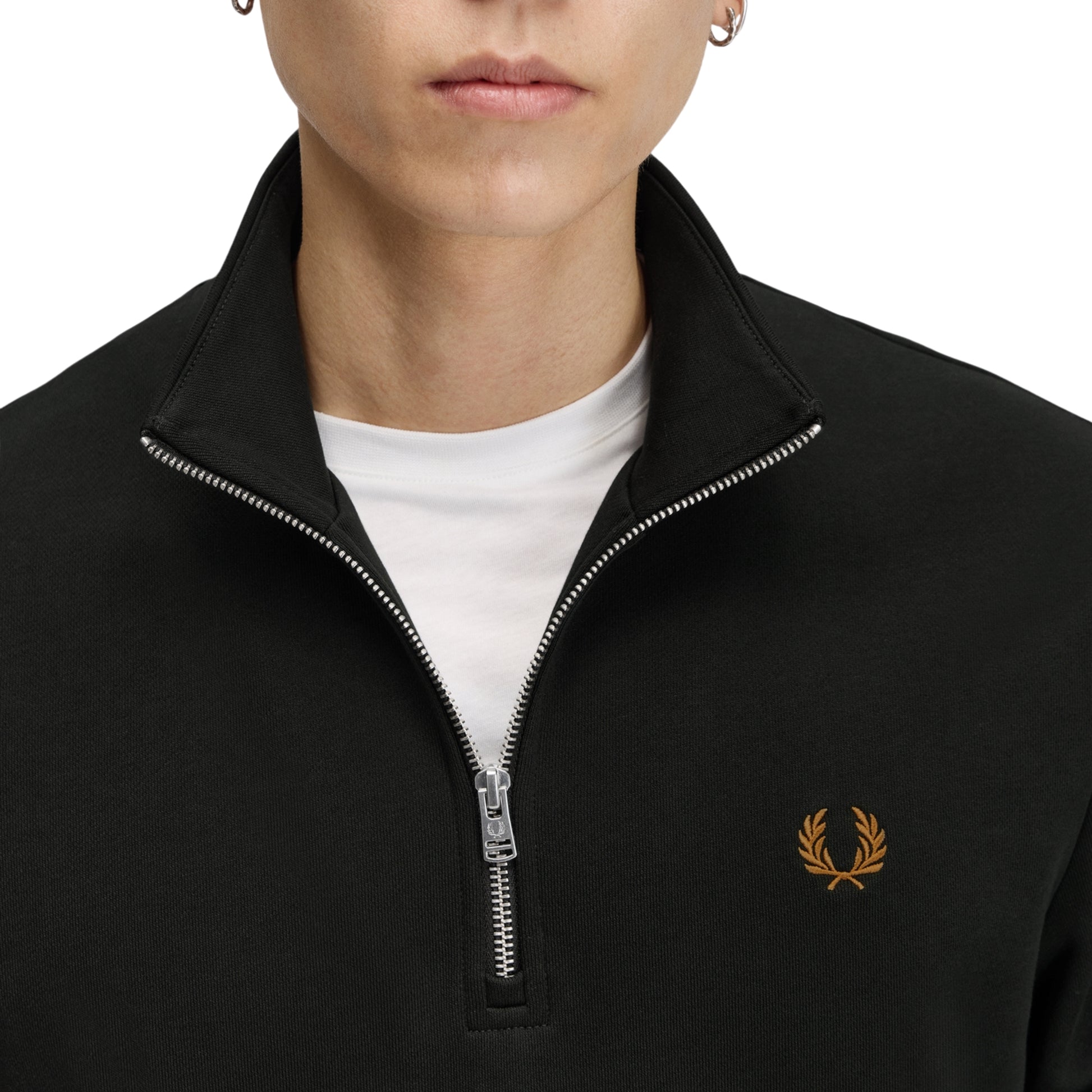 Sweat com meio-fecho Fred Perry Half Zip Sweatshirt em Night Green — detalhe do meio-fecho aberto em calibre fino e bordado Laurel Wreath em Dark Caramel no peito esquerdo, t-shirt branca por baixo visível.