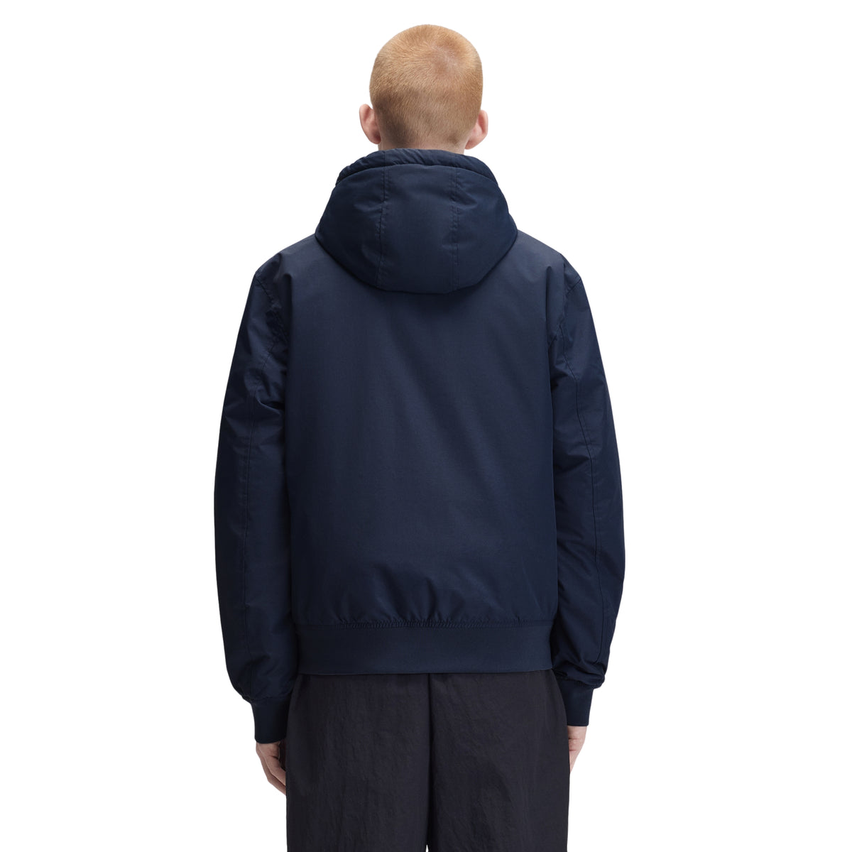 Casaco com carapuço para homem Fred Perry Hooded Brentham Jacket em Dark Airforce — modelo masculino de costas, meio corpo, casaco azul-marinha escuro com capuz volumoso, costas lisas, punhos canelados, regular fit, calças pretas, fundo branco.