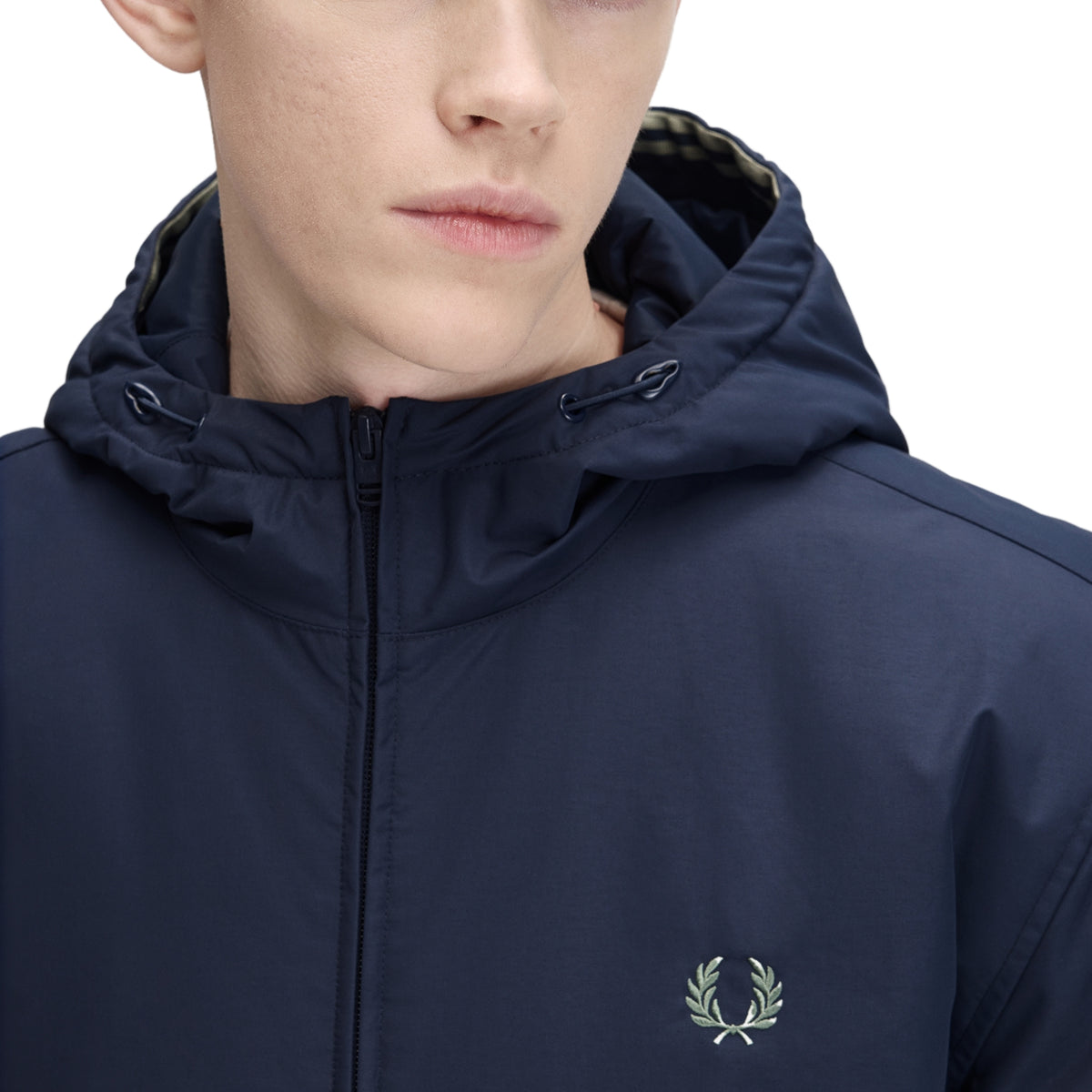 Casaco com carapuço para homem Fred Perry Hooded Brentham Jacket em Dark Airforce — detalhe do carapuço e zona do pescoço, casaco azul-marinha escuro fechado, cordões de ajuste do carapuço visíveis, twin tipping interior em bege/champanhe na borda do carapuço, logo laurel wreath bordado a prata no peito esquerdo, fundo branco.