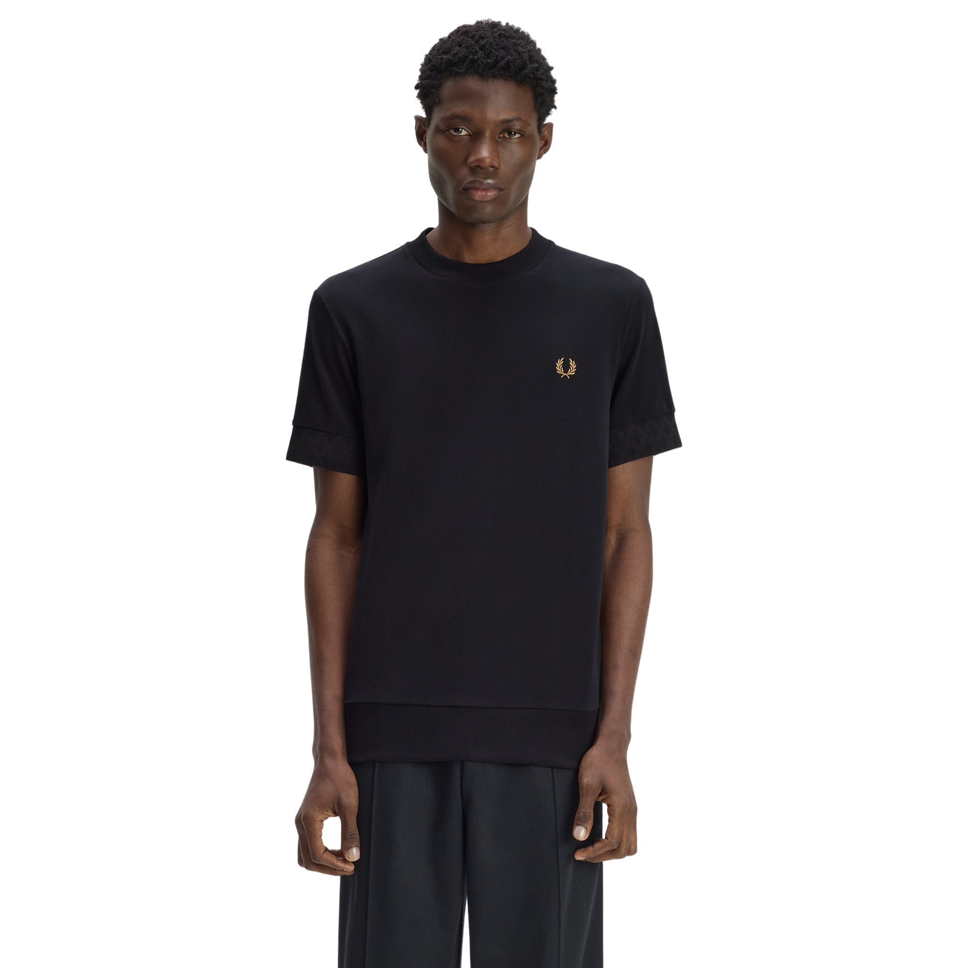 T-shirt Fred Perry Jacquard Cuff T-Shirt em Black — vista frontal com modelo, meio corpo, detalhe jacquard tonal nos punhos, gola redonda bound, bordado Laurel Wreath no peito esquerdo.