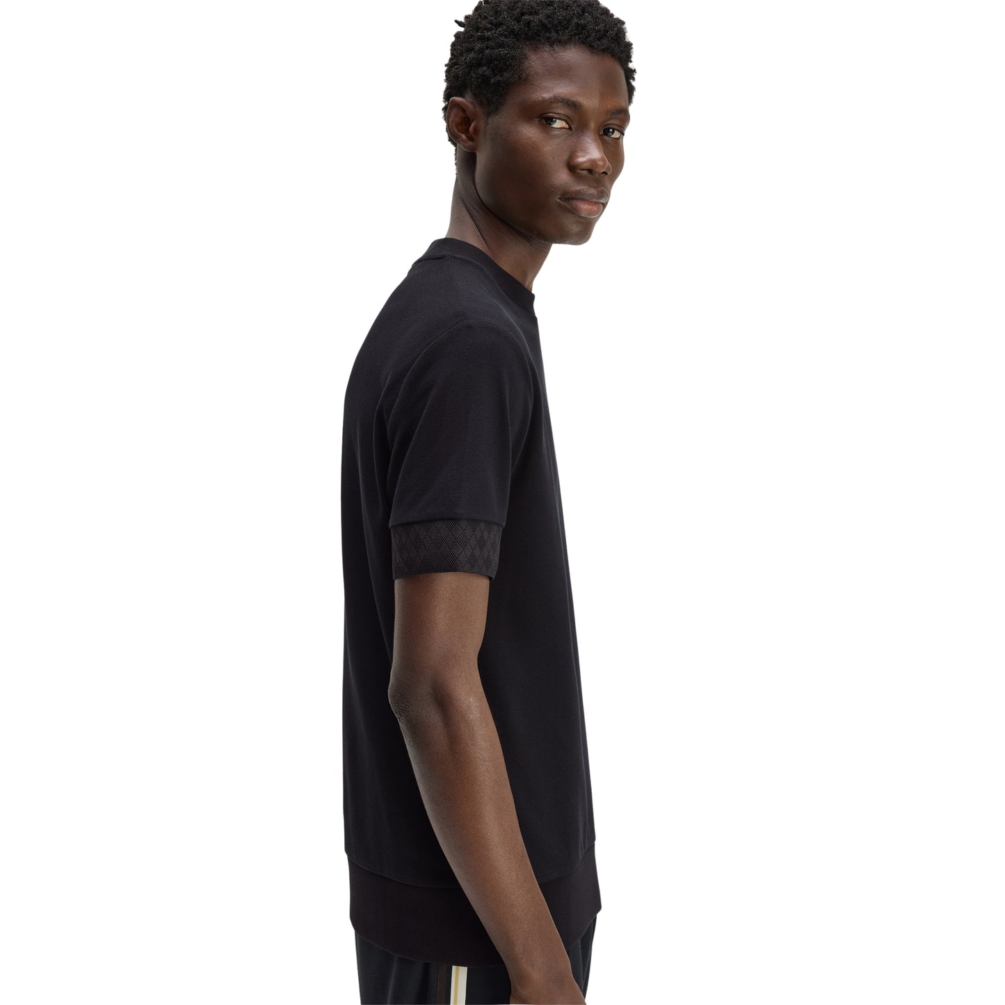 T-shirt Fred Perry Jacquard Cuff T-Shirt em Black — vista lateral com modelo, corpo inteiro, perfil da gola bound e punhos jacquard visíveis.