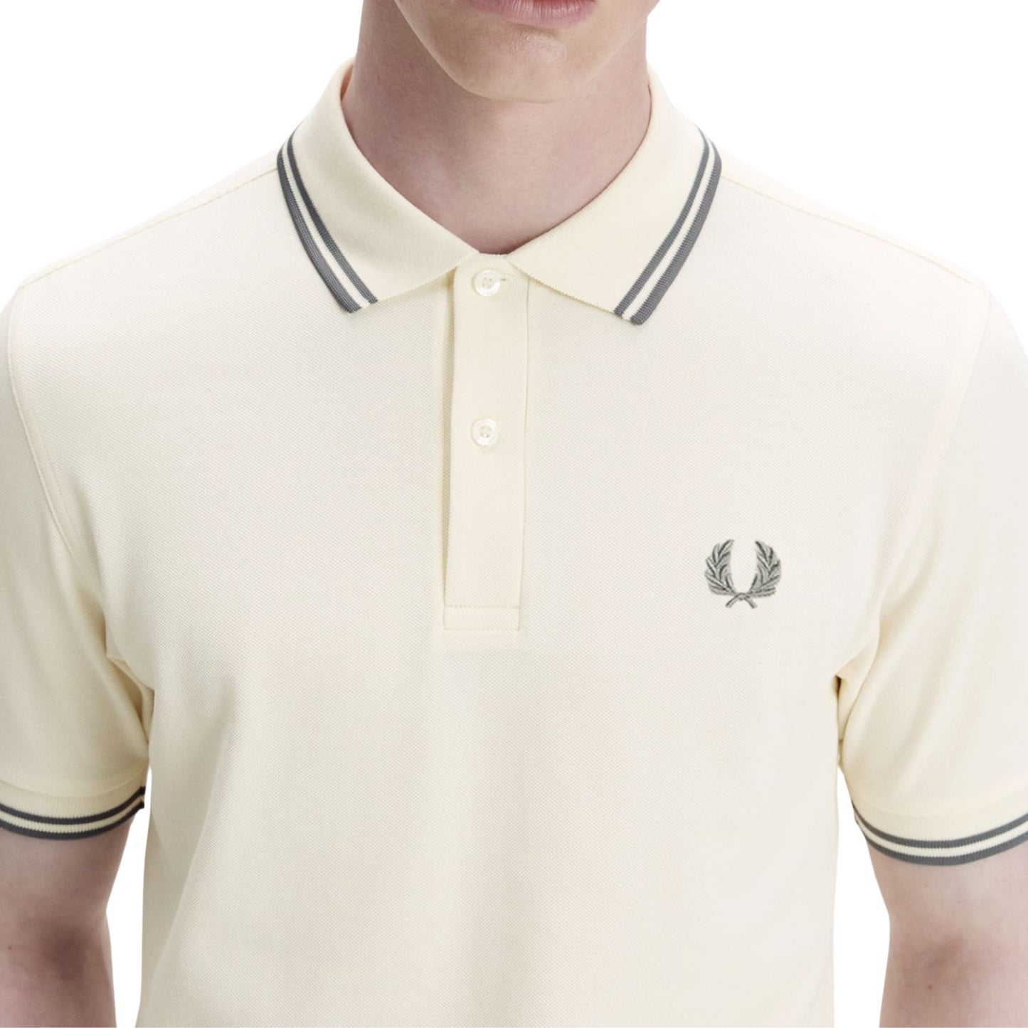 Polo de manga curta para homem Fred Perry M3600 em Ecru/Azul Stockport. Foto de detalhe da parte da frente, vestido.
