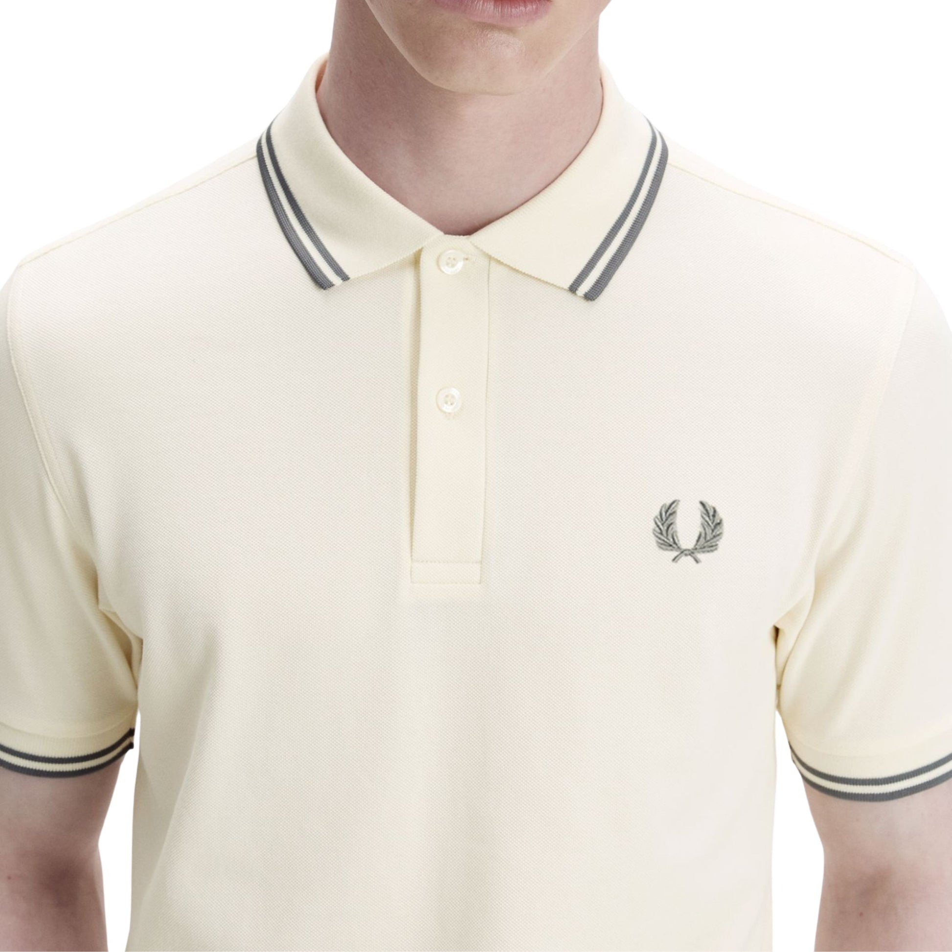 Polo de manga curta para homem Fred Perry M3600 em Ecru/Azul Stockport. Foto de detalhe da parte da frente, vestido.
