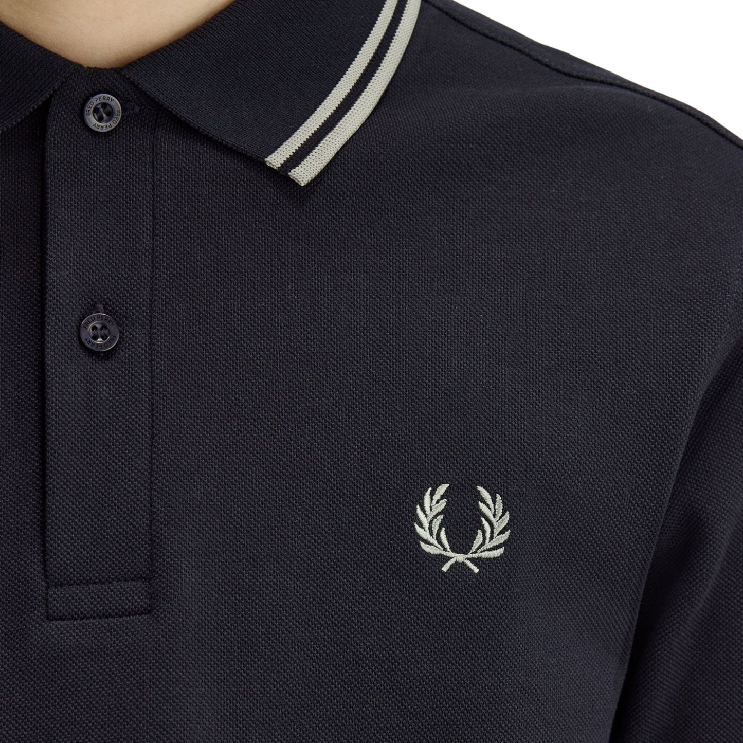 Polo de manga curta para homem Fred Perry M3600 em Azul Marinho/Seagrass/Seagrass. Foto de detalhe da parte da frente, vestido.