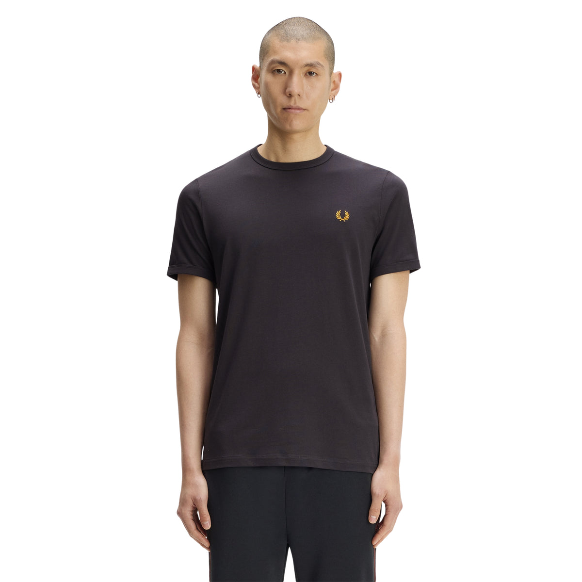 T-shirt de manga curta para homem Fred Perry Ringer T-Shirt em Anchor Grey — modelo masculino de frente, corpo inteiro, jersey cinzento carvão Anchor Grey, gola redonda canelada em contraste, logo laurel wreath bordado a dourado no peito esquerdo, regular fit, calças pretas, fundo branco.