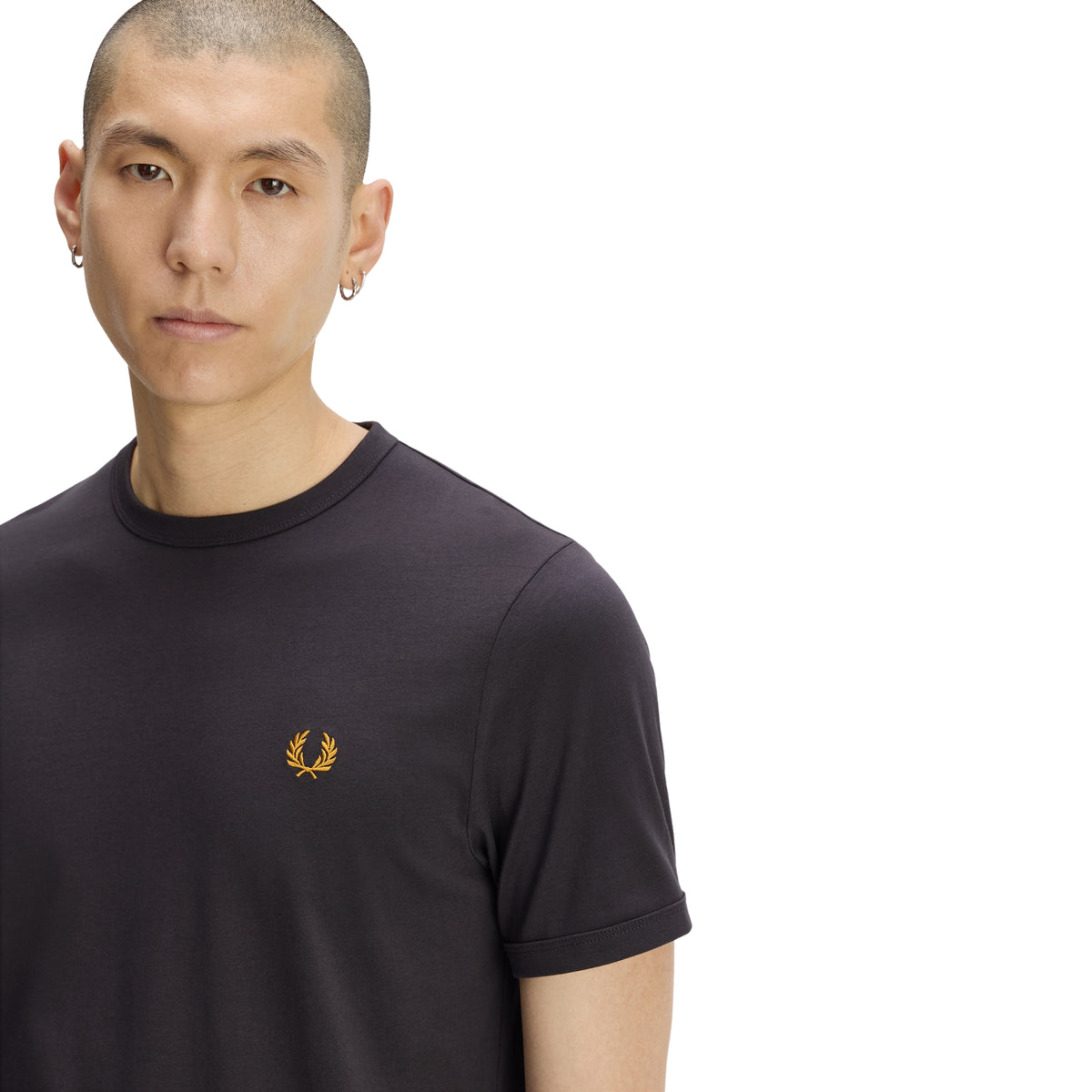 T-shirt de manga curta para homem Fred Perry Ringer T-Shirt em Anchor Grey — modelo masculino de frente, meio corpo, jersey cinzento carvão Anchor Grey, gola redonda canelada em contraste, logo laurel wreath bordado a dourado no peito esquerdo em destaque, regular fit, fundo branco.