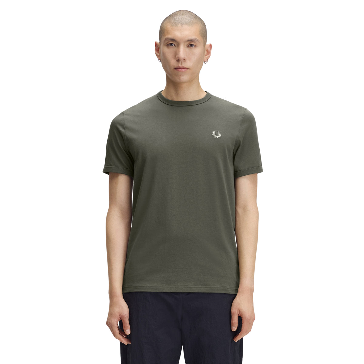 T-shirt de manga curta para homem Fred Perry Ringer T-Shirt em Field Green — modelo masculino de frente, corpo inteiro, jersey verde-musgo Field Green, gola redonda canelada em contraste escuro, logo laurel wreath bordado a creme no peito esquerdo, regular fit, calças azul-marinho, fundo branco.