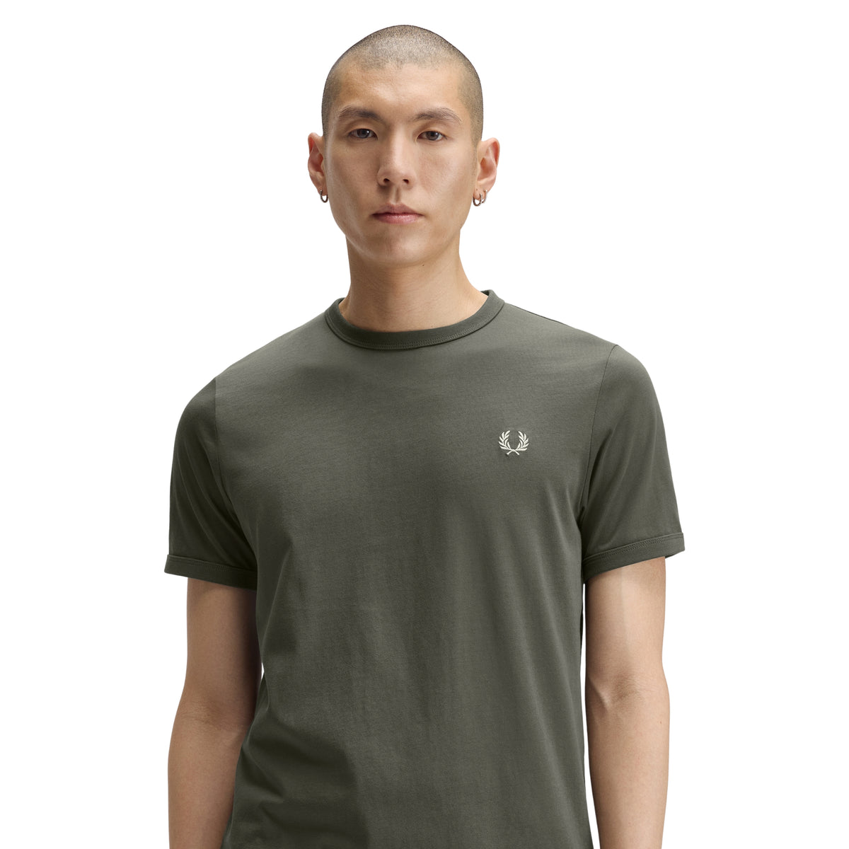 T-shirt de manga curta para homem Fred Perry Ringer T-Shirt em Field Green — modelo masculino de frente, meio corpo, jersey verde-musgo Field Green, gola redonda canelada em contraste escuro, logo laurel wreath bordado a creme no peito esquerdo, regular fit, fundo branco.