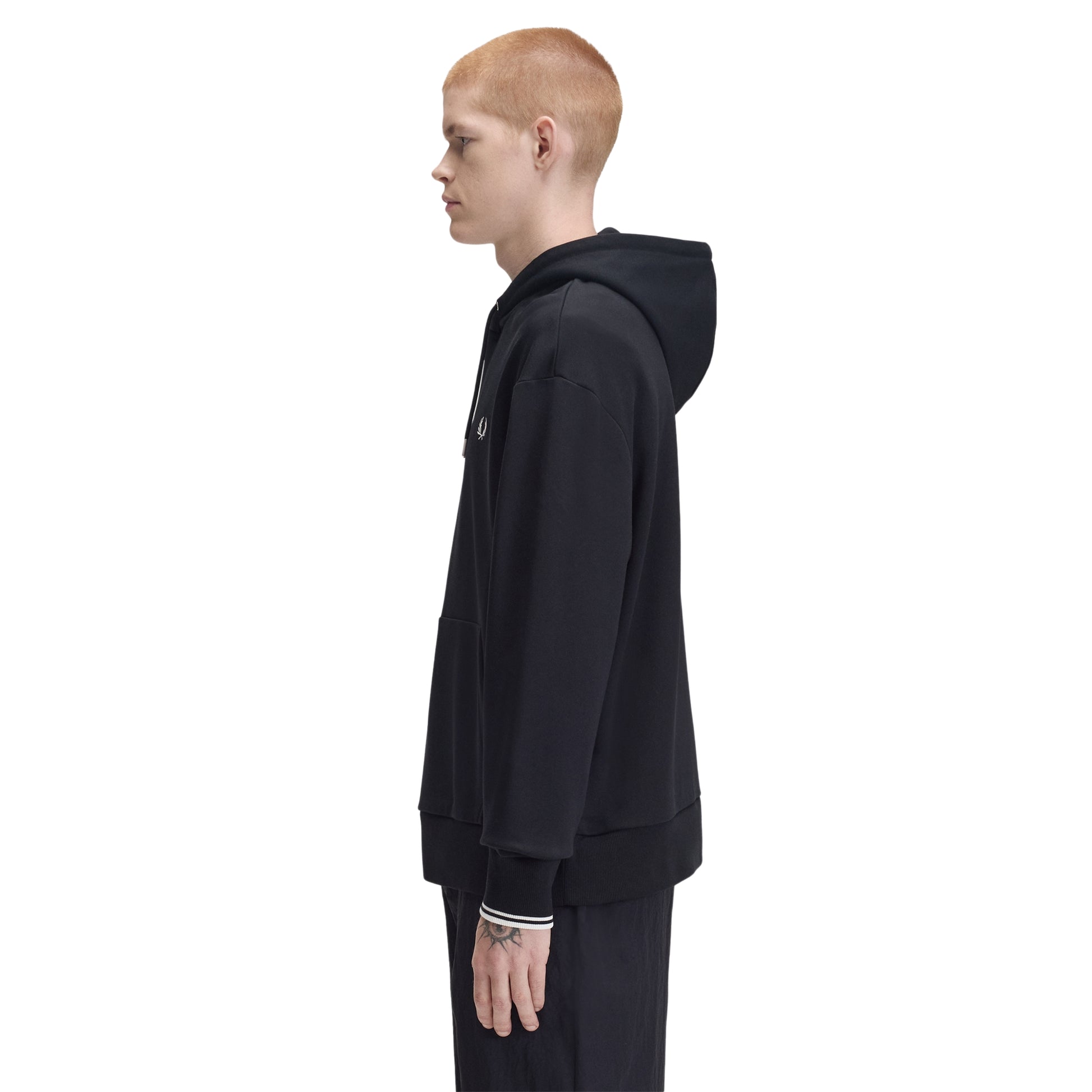 Sweat com carapuço Fred Perry Tipped Hooded Sweatshirt em Black — vista frontal com modelo, corpo inteiro, corte relaxed, bolso canguru e twin tipping nos punhos visíveis.