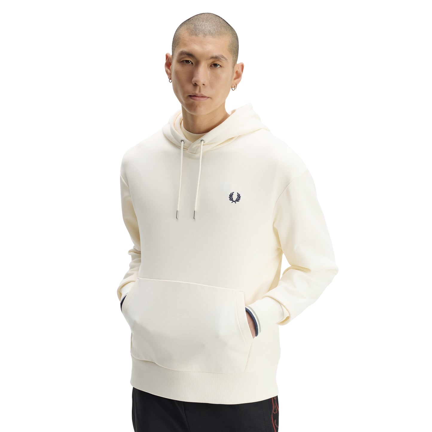Sweat com carapuço Fred Perry Tipped Hooded Sweatshirt em Ecru — vista frontal com modelo, meio corpo, capota com cordões, bordado Laurel Wreath no peito esquerdo, twin tipping nos punhos visível.