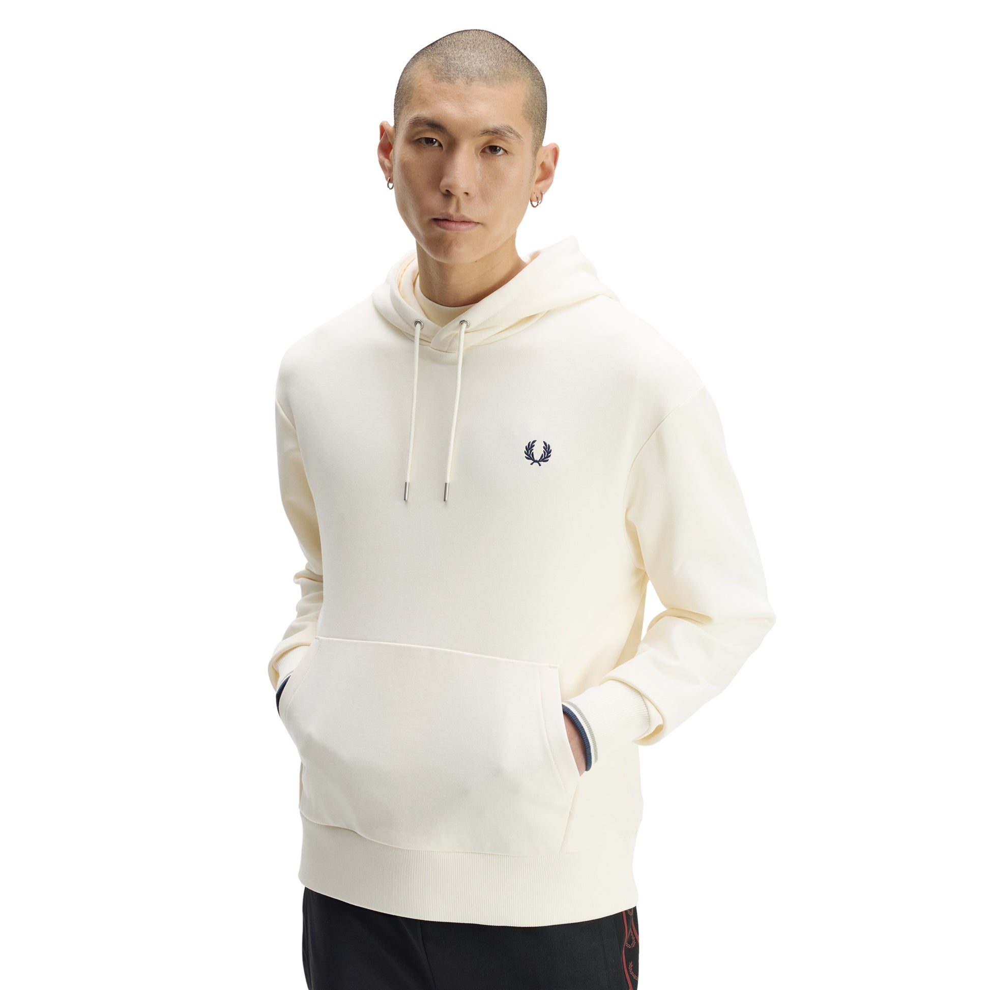 Sweat com carapuço Fred Perry Tipped Hooded Sweatshirt em Ecru — vista frontal com modelo, meio corpo, capota com cordões, bordado Laurel Wreath no peito esquerdo, twin tipping nos punhos visível.