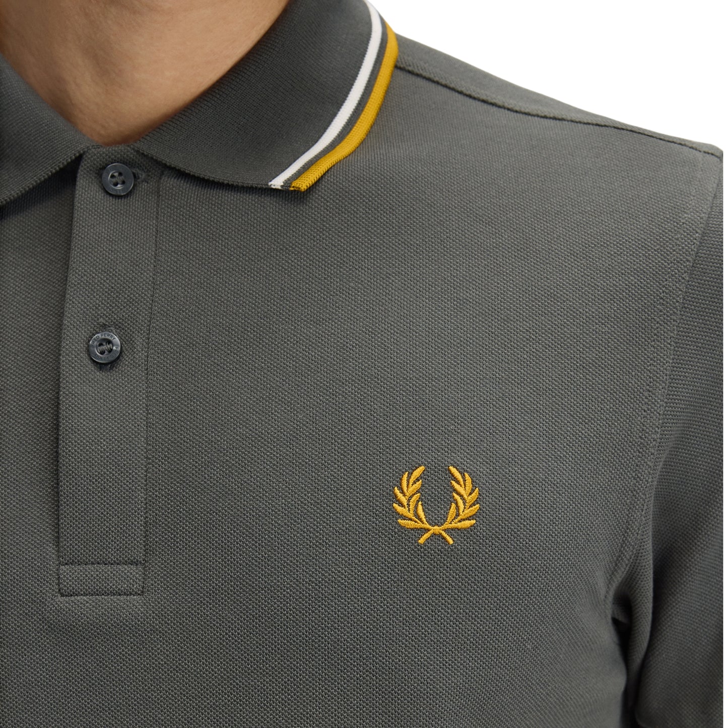 Polo de manga curta para homem Fred Perry Twin Tipped em Field Green/Ecru/Golden. Foto de detalhe da parte da frente, vestido.