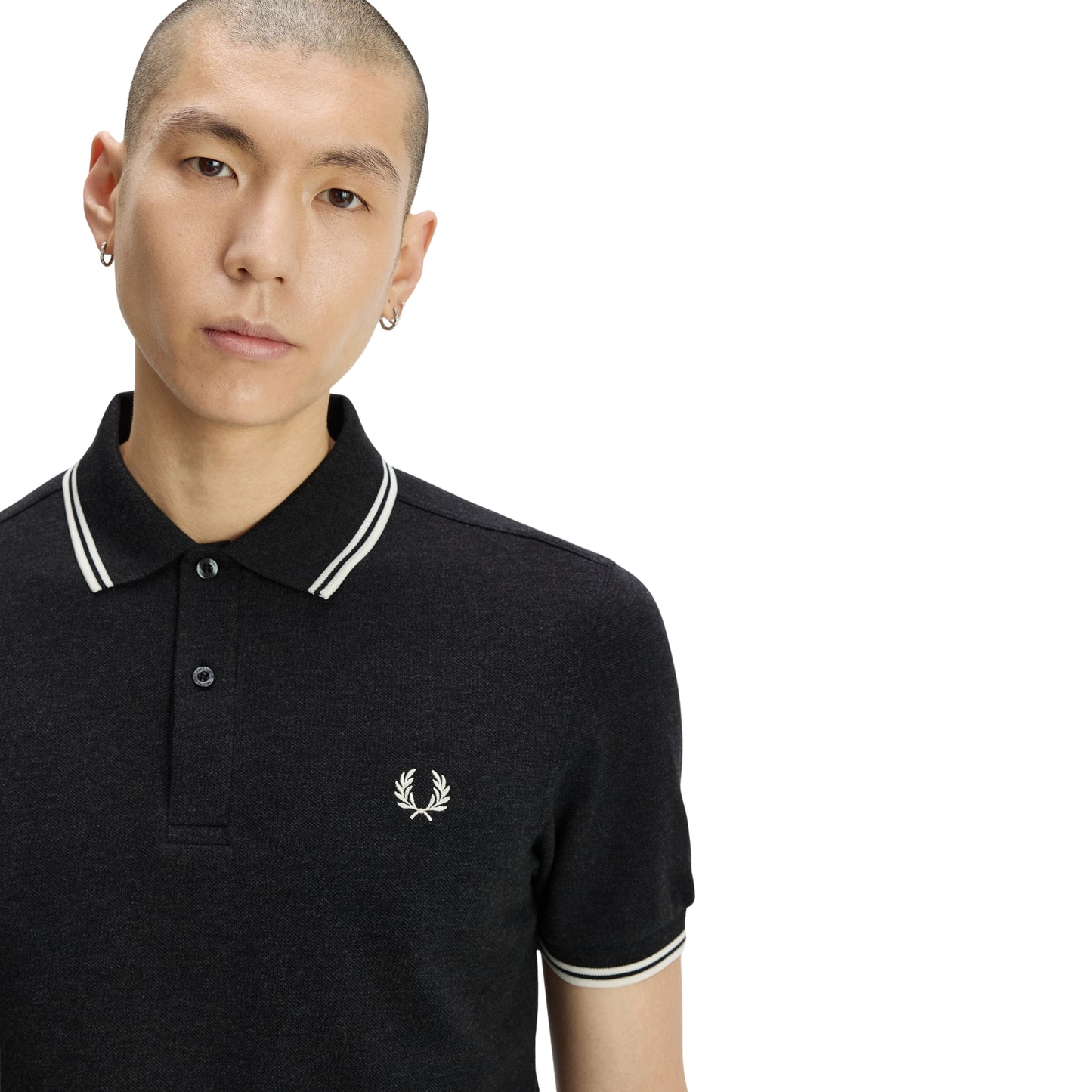 Polo de manga curta Fred Perry M3600 em Charcoal Marl / Ecru / Ecru — detalhe do twin tipping Ecru na gola na proporção 5-4-4 e bordado Laurel Wreath em Ecru no peito esquerdo, close-up com modelo.