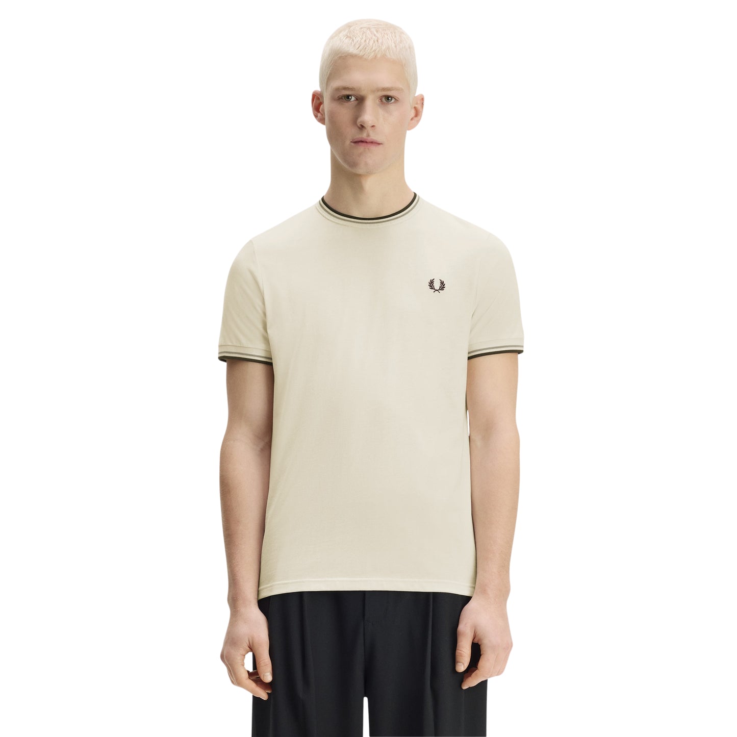 T-shirt Fred Perry Twin Tipped T-Shirt em Ecru — vista frontal com modelo, corpo inteiro, braços ao longo do corpo, bordado Laurel Wreath em Dark Airforce e twin tipping no colarinho e punhos visíveis, combinado com calças pretas.