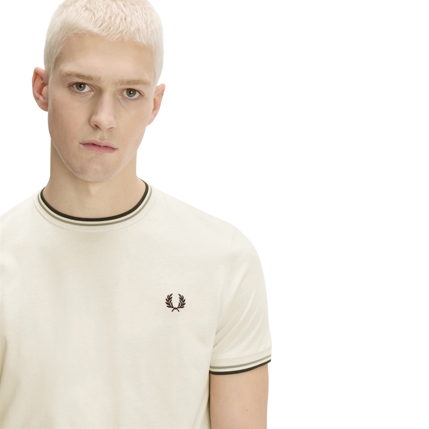 T-shirt Fred Perry Twin Tipped T-Shirt em Ecru — detalhe do bordado Laurel Wreath em Dark Airforce no peito esquerdo e twin tipping Seagrass/Dark Airforce no colarinho, close-up com modelo.