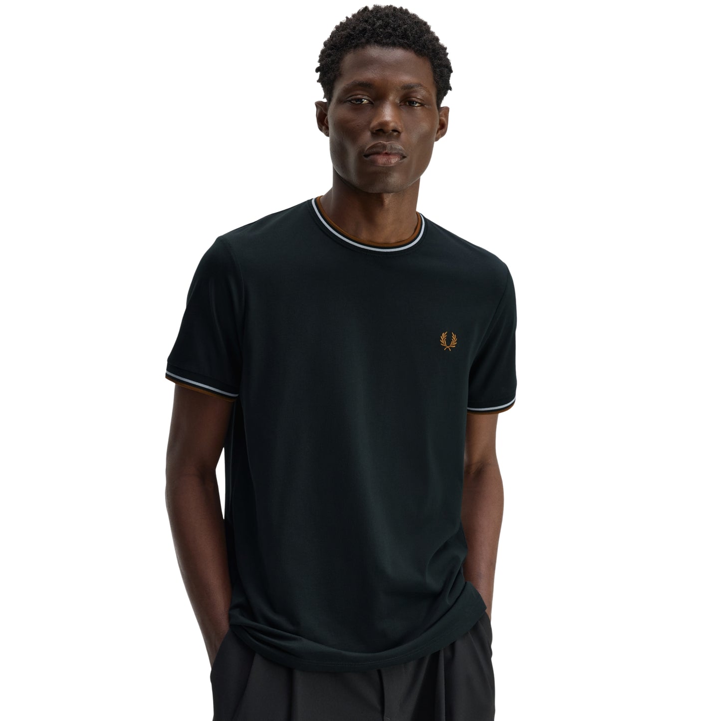 T-shirt Fred Perry Twin Tipped T-Shirt em Night Green — vista lateral com modelo, corpo inteiro, perfil da gola redonda e twin tipping Dusky Blue/Dark Caramel no colarinho e punho visíveis.