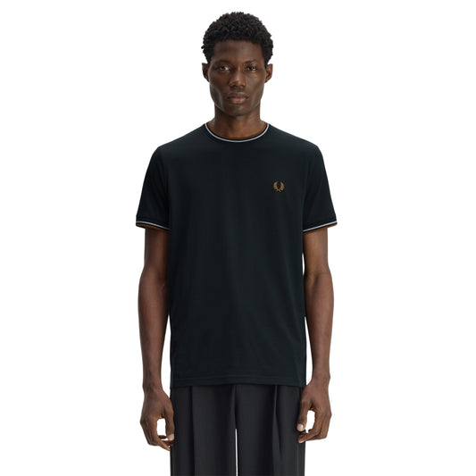 T-shirt Fred Perry Twin Tipped T-Shirt em Night Green — vista frontal com modelo, meio corpo, bordado Laurel Wreath em Dark Caramel no peito esquerdo, twin tipping Dusky Blue/Dark Caramel no colarinho e punhos.