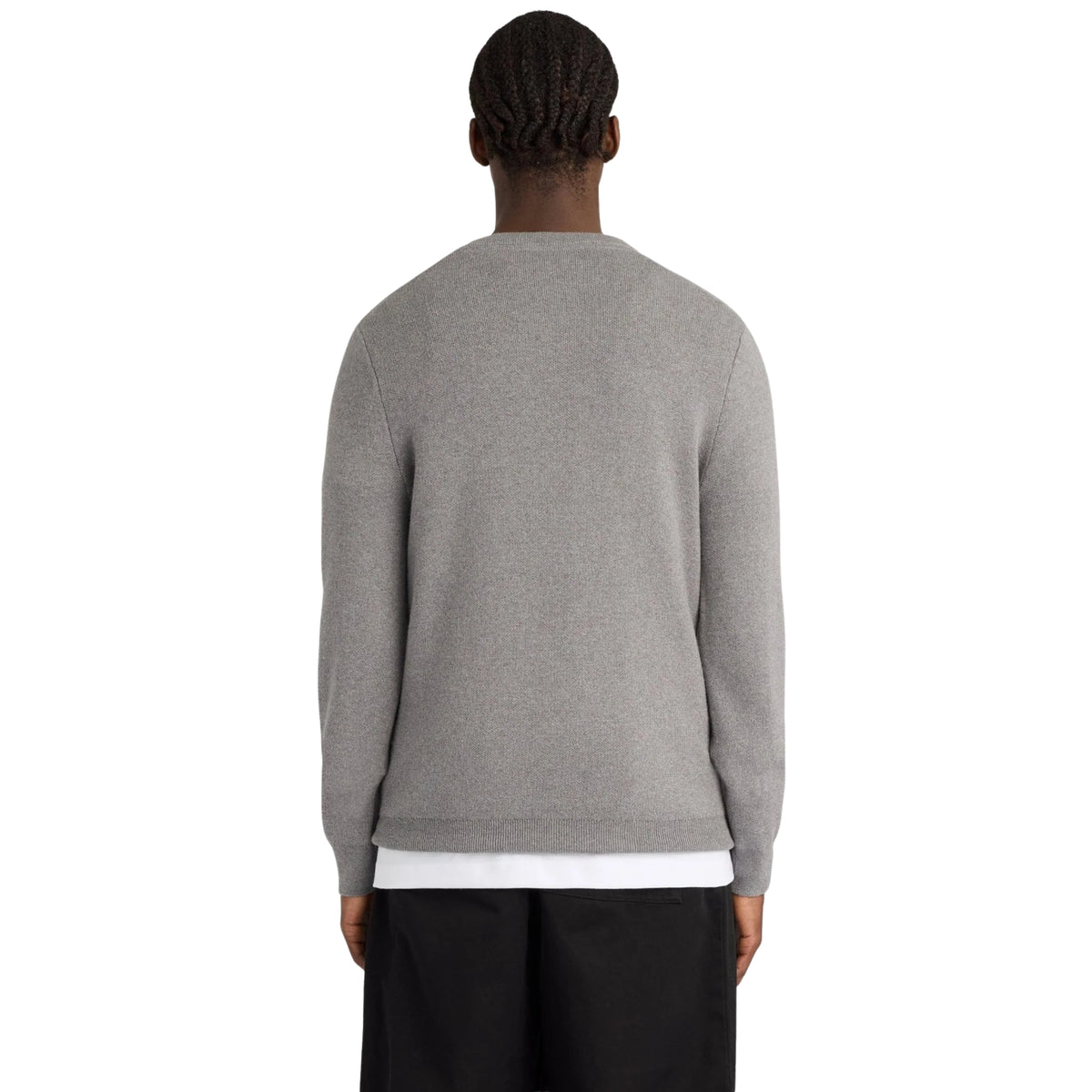 Vista de costas da camisola Lyle & Scott Cotton Merino Argyle, vestida por modelo, com malha lisa cinzenta e bainha canelada.