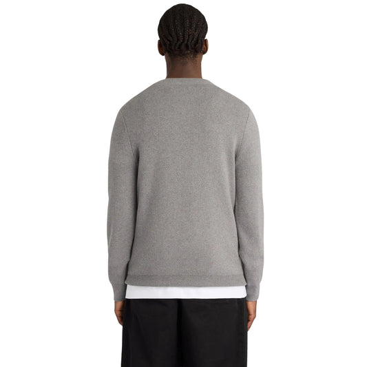Vista de costas da camisola Lyle & Scott Cotton Merino Argyle, vestida por modelo, com malha lisa cinzenta e bainha canelada.