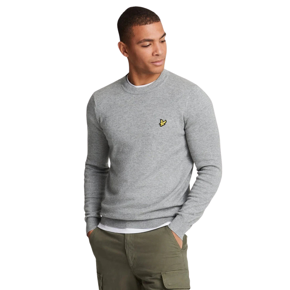 Camisola Lyle & Scott Cotton Merino em Mid Grey Marl vestida por modelo de frente, com gola redonda e águia amarela no peito.