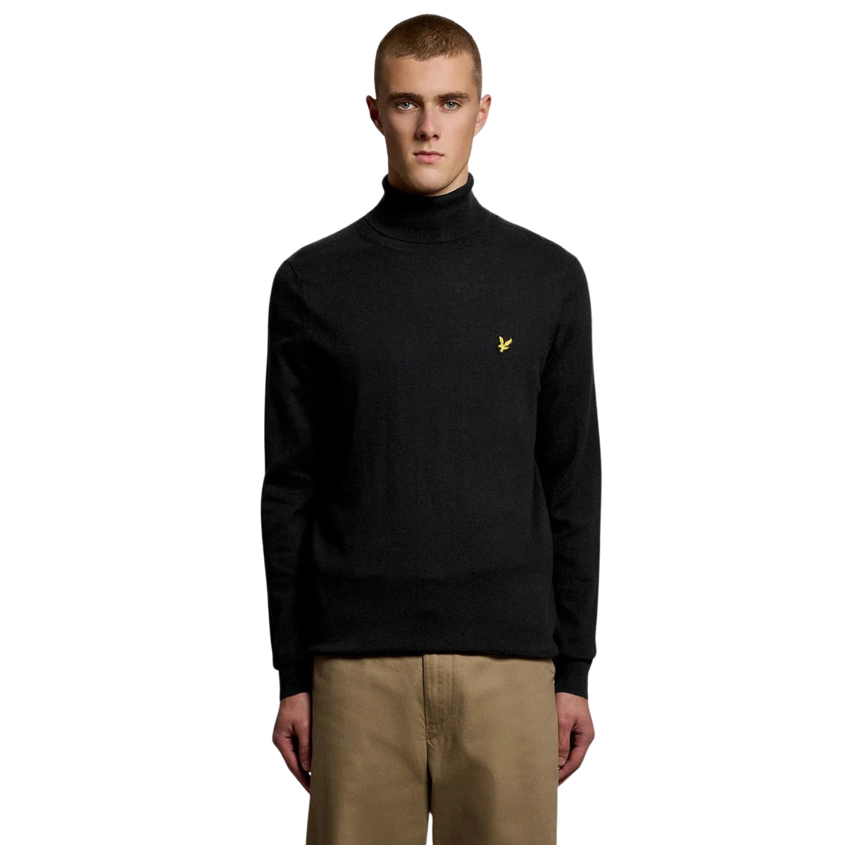 Camisola de gola alta Lyle & Scott Cotton Merino em Jet Black vestida por modelo de frente, com águia amarela no peito.