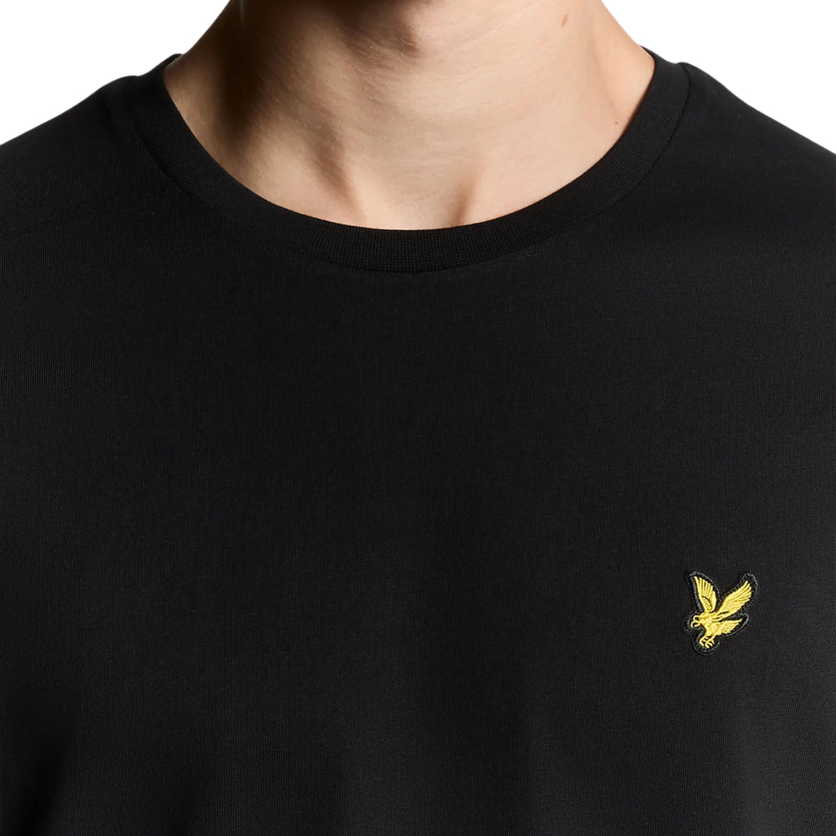 Pormenor da gola redonda canelada e da águia dourada no peito da t-shirt Lyle & Scott Plain Jet Black.