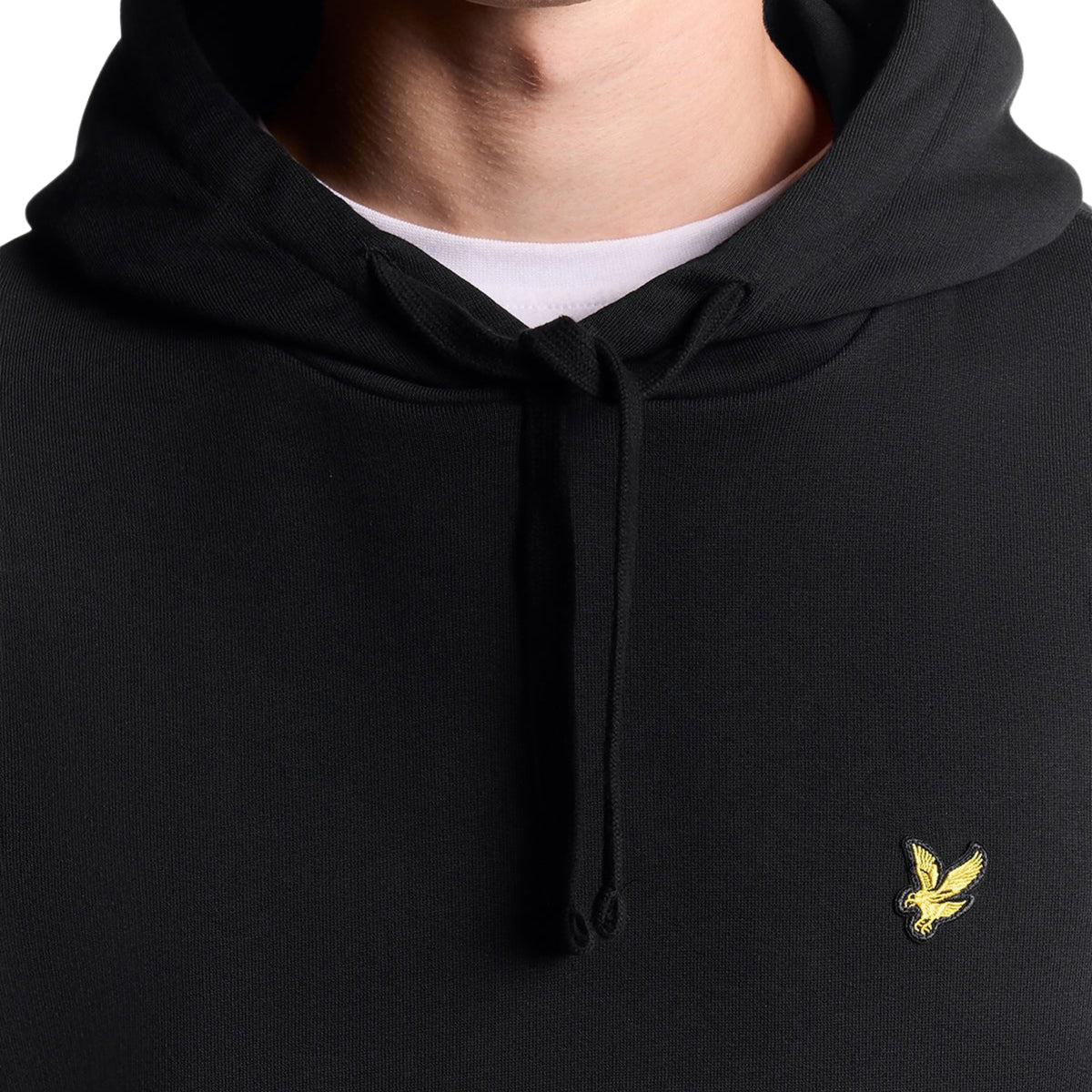 Pormenor do capuz com cordão e da águia amarela no peito da sweat Lyle & Scott Pullover Jet Black.