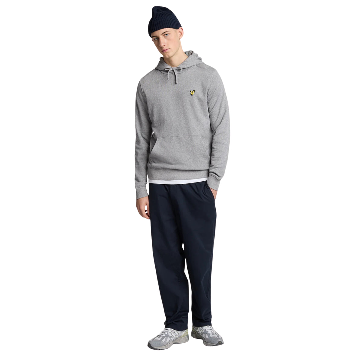 Modelo de corpo inteiro com hoodie Lyle & Scott Pullover Mid Grey Marl, gorro escuro, calças escuras e sapatilhas cinzentas.