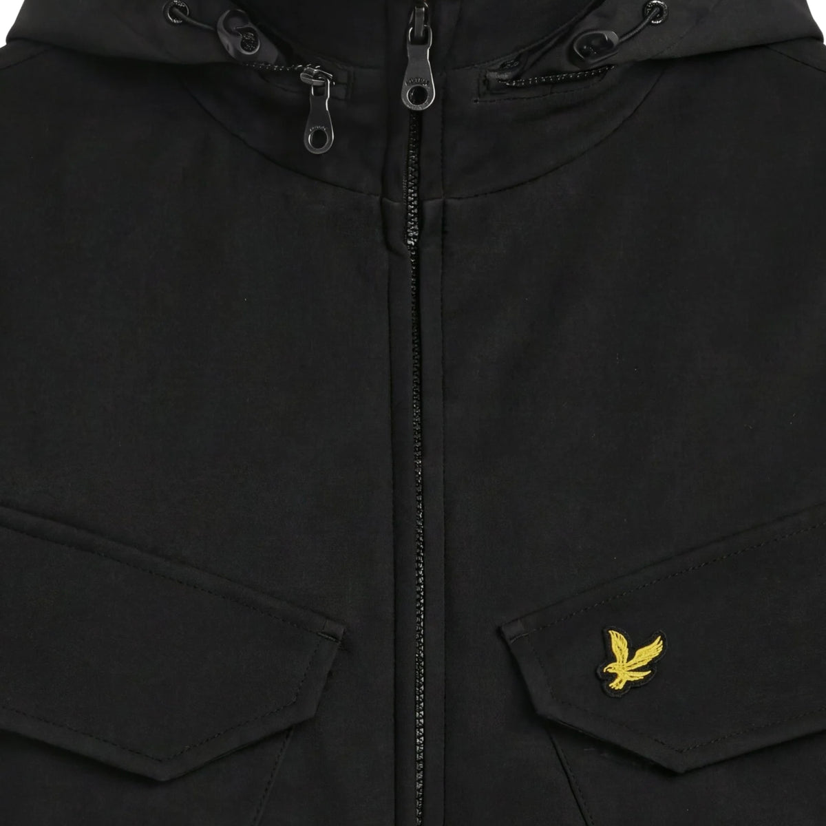 Pormenor do fecho, ajustes do capuz e águia amarela bordada na pala do bolso do casaco Lyle & Scott Softshell Field preto.