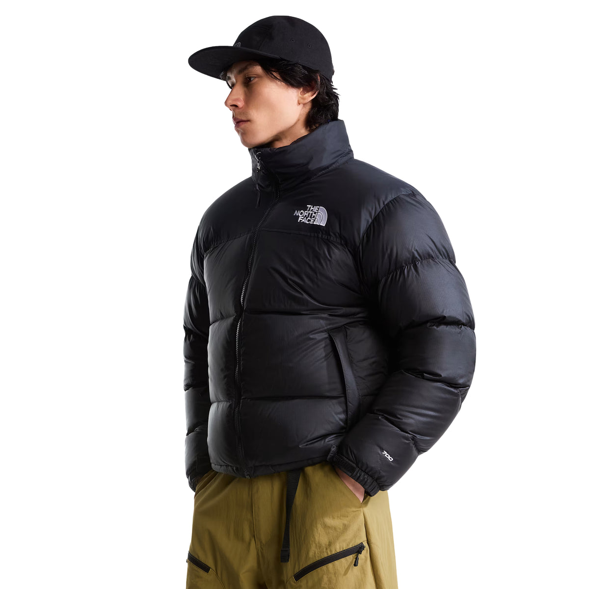 Casaco The North Face 1996 Retro Nuptse preto em modelo de frente a três quartos, com gola levantada, painéis acolchoados e logótipo branco no peito.