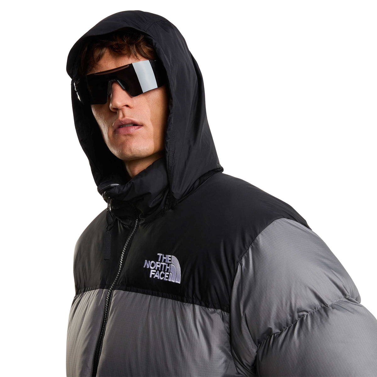 Pormenor do capuz preto levantado e do logótipo no peito do casaco The North Face 1996 Retro Nuptse Smoked Pearl/TNF Black.