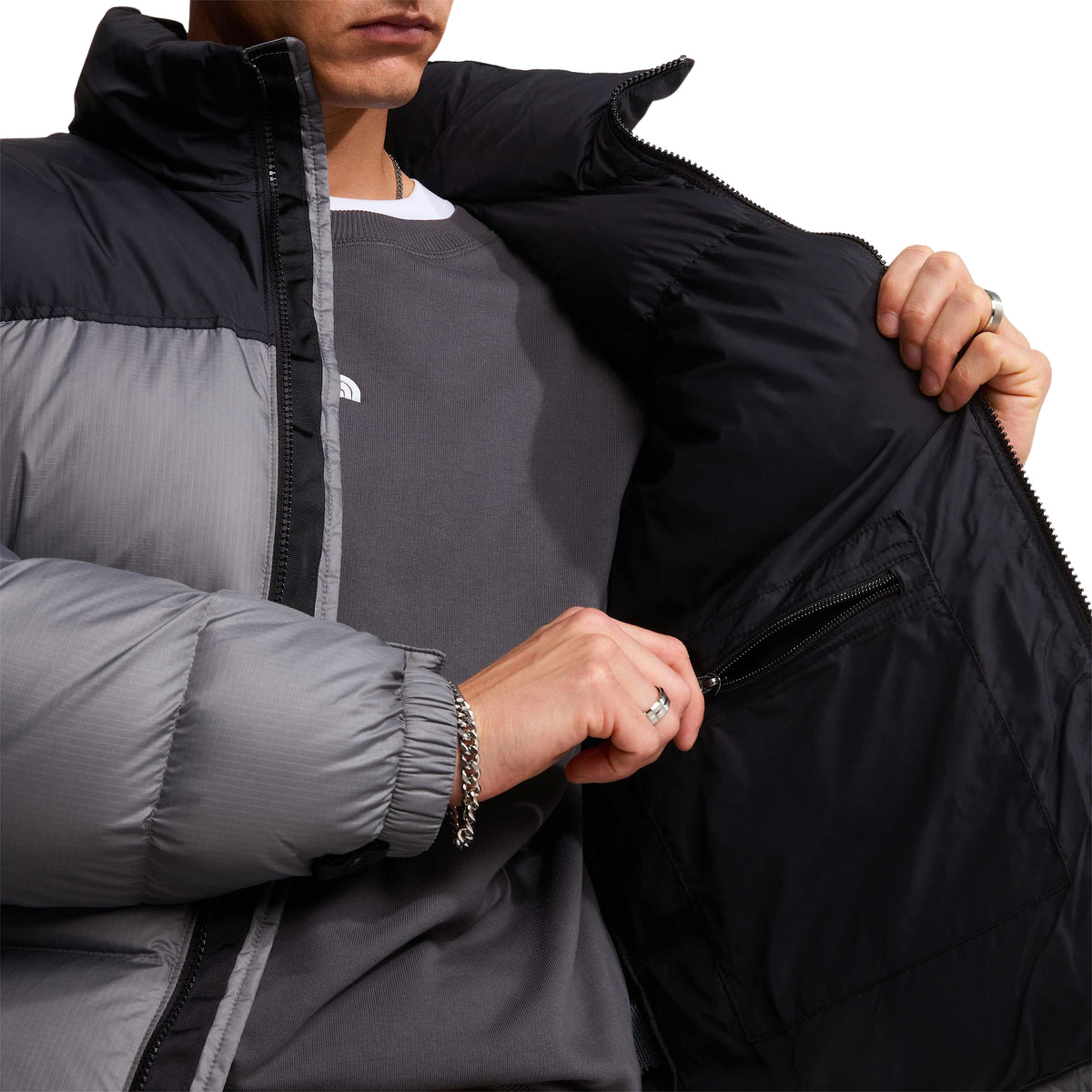 Pormenor do forro preto e do bolso interior com fecho do casaco The North Face 1996 Retro Nuptse Smoked Pearl/TNF Black.