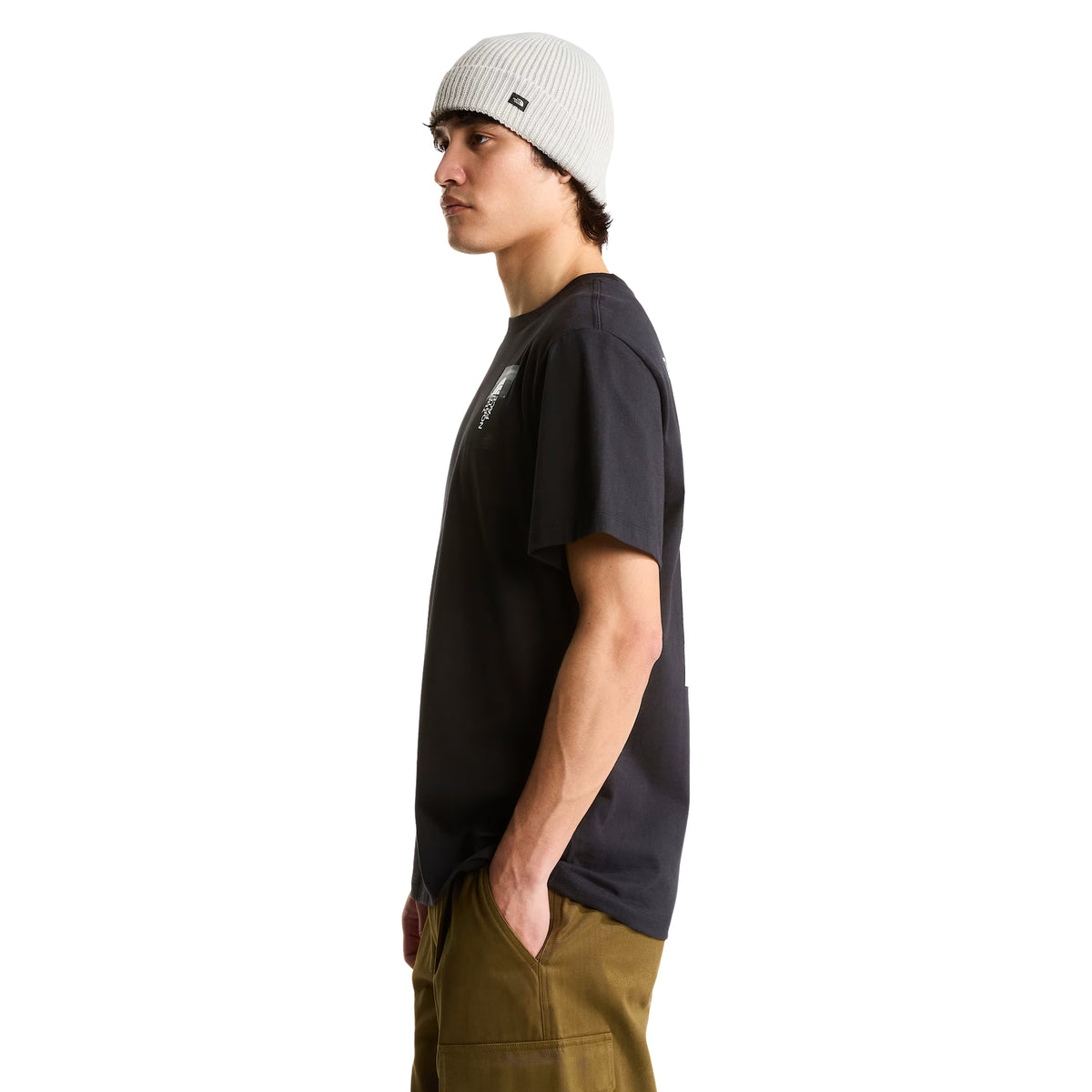 T-shirt de manga curta The North Face Apex '75 Collage em preto — modelo masculino de perfil, meio corpo, peito esquerdo com logótipo The North Face em retângulo fotográfico preto/branco, gola redonda canelada, corte relaxed, gorro cinzento, fundo branco.