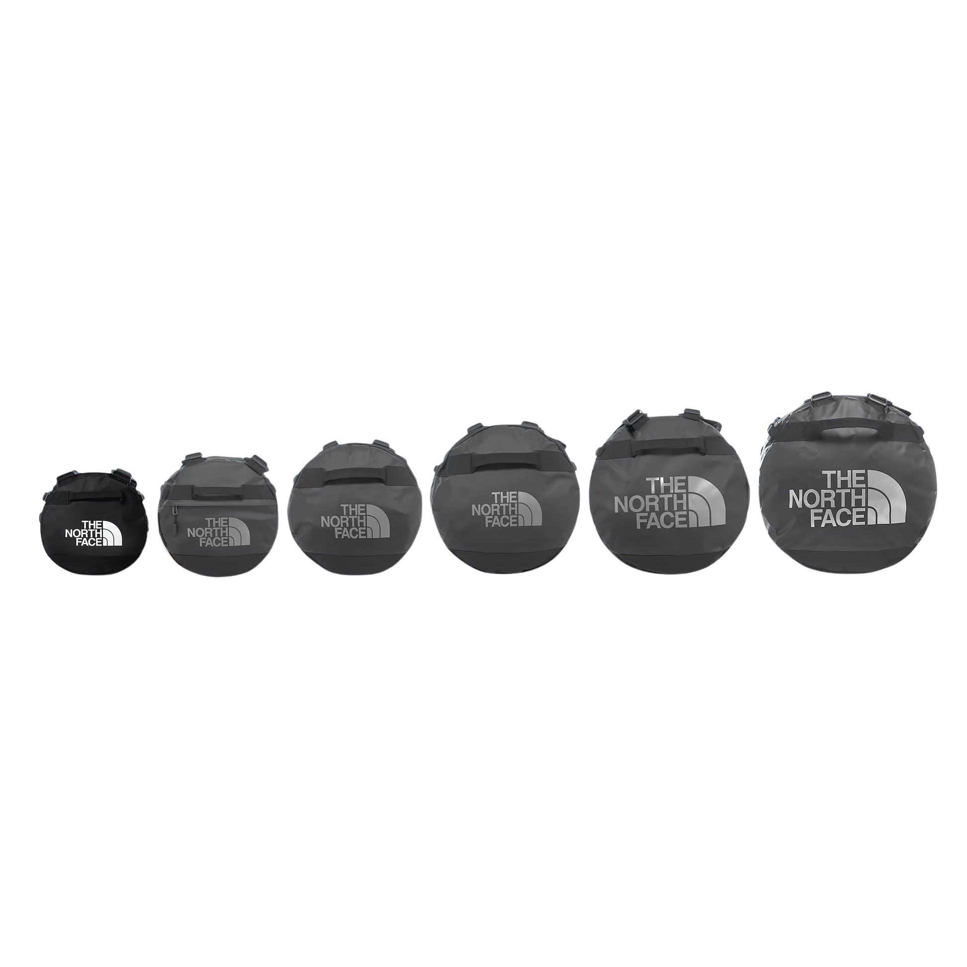 Comparação de tamanhos da gama The North Face Base Camp Duffel em TNF Black — 6 sacos alinhados por tamanho crescente da esquerda para a direita (XS ao XXL), logo TNF em branco no menor e em cinzento nos restantes, fundo branco.