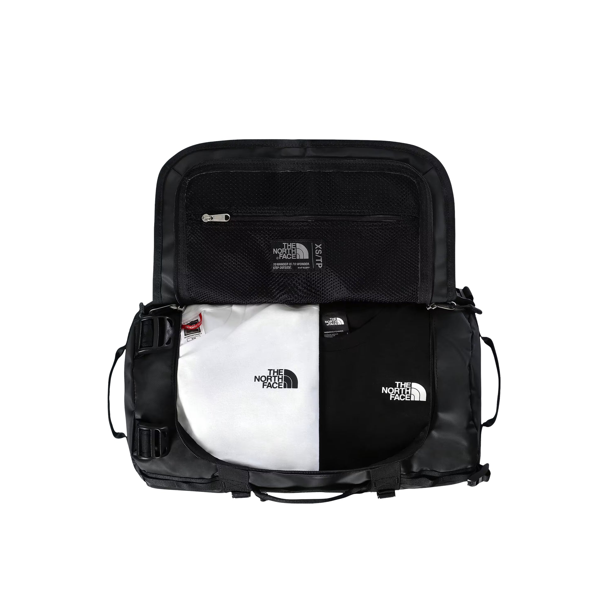 Saco de viagem The North Face Base Camp Duffel XS em TNF Black — interior aberto visto de cima, compartimento principal com dois sacos TNF dobrados em branco e preto, tampa interior com bolso de malha e zip prateado e etiqueta TNF XS/TP visíveis, fundo branco.