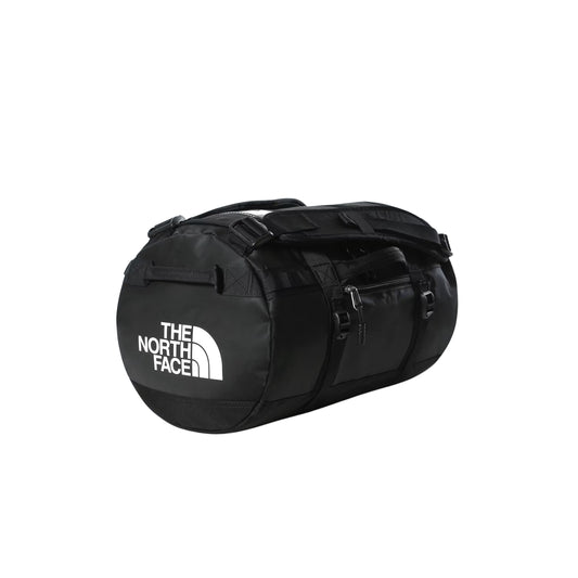 Saco de viagem The North Face Base Camp Duffel XS em TNF Black — vista frontal a 3/4, produto sem modelo, logo TNF em branco no painel frontal, fecho principal em U, bolso frontal com zip e fivelas de ajuste pretas visíveis, fundo branco.