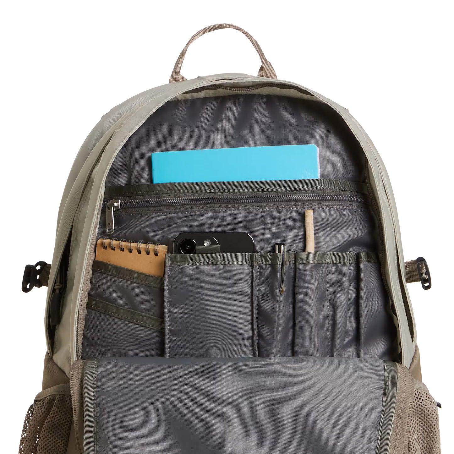 Mochila The North Face Borealis Classic em Cumulus Cloud / Stone Slab — interior do bolso frontal aberto em Anthracite Grey, com caderno kraft, smartphone preto, porta-canetas com lápis e caneta, e caderno azul no bolso zip superior visíveis, fundo branco.